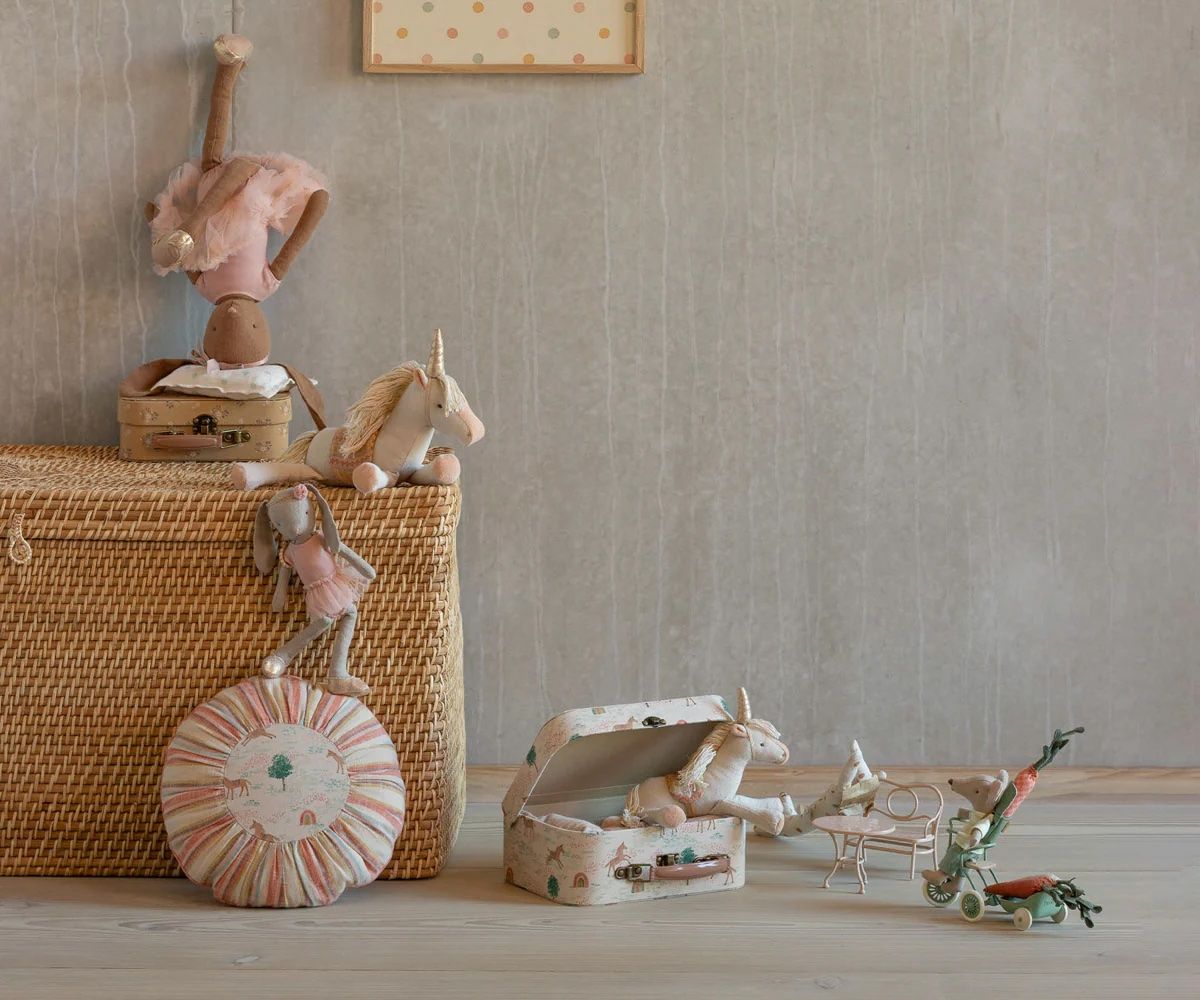 A sequence of five minimalist still life photos showing toys and decorative objects arranged with woven baskets.