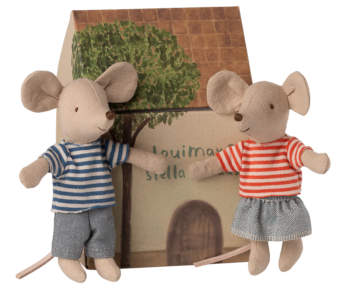 A row of stuffed mouse toys wearing striped shirts and denim skirts sit on wooden blocks.