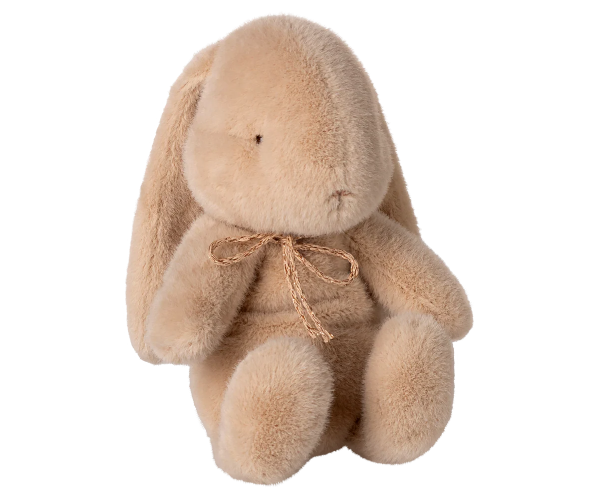 Multiple views of a soft beige plush elephant toy with floppy ears and a small bow around its neck.