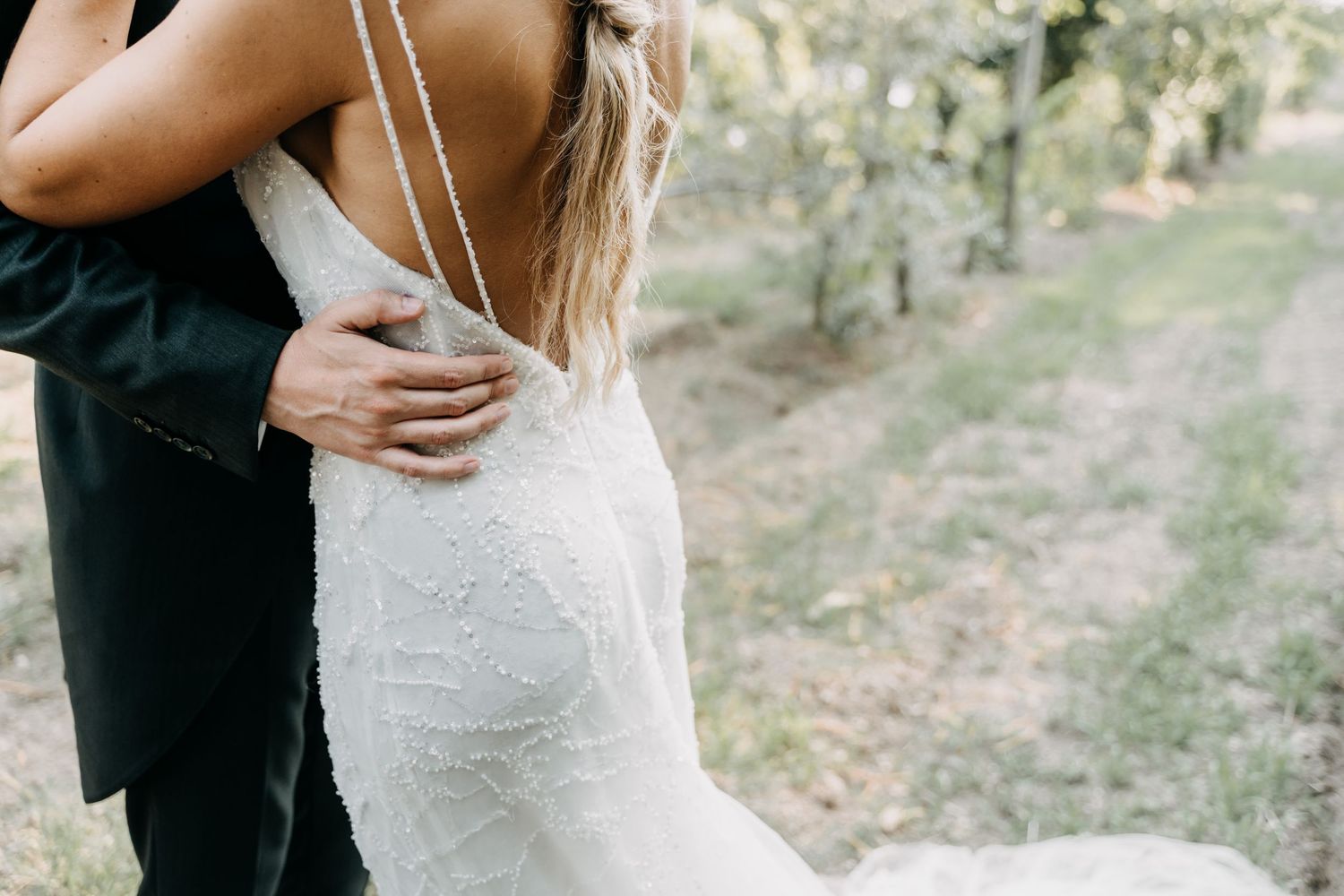 A bride and groom share intimate moments in an outdoor wooded setting during their wedding photo session.