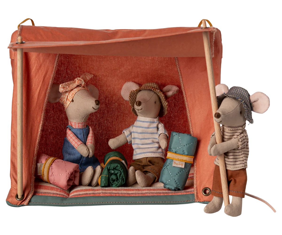 A collection of plush stuffed animals arranged on wooden shelves with a coral pink background.