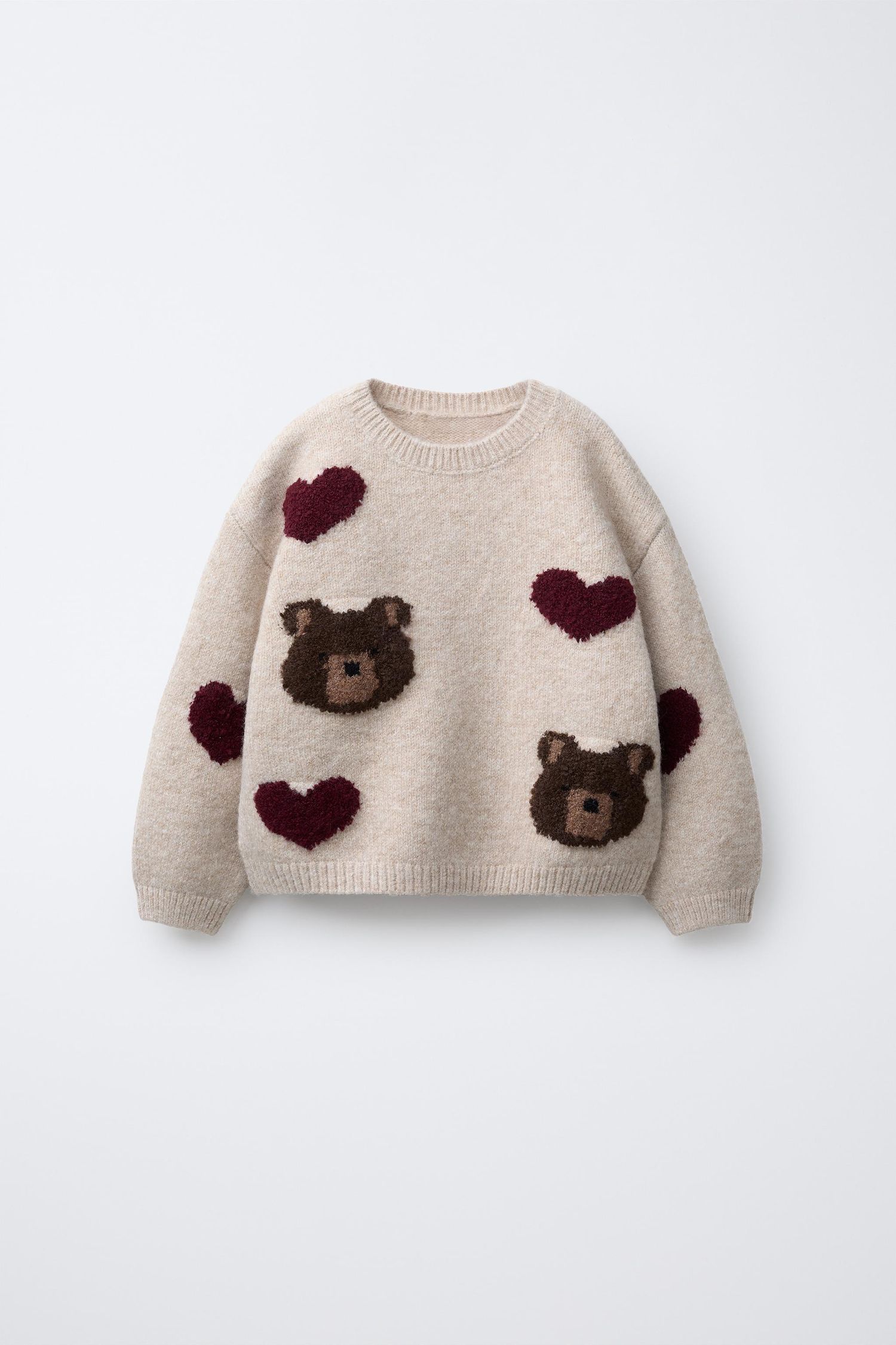 Beige knit sweater featuring adorable brown teddy bear and burgundy heart pattern decorations.