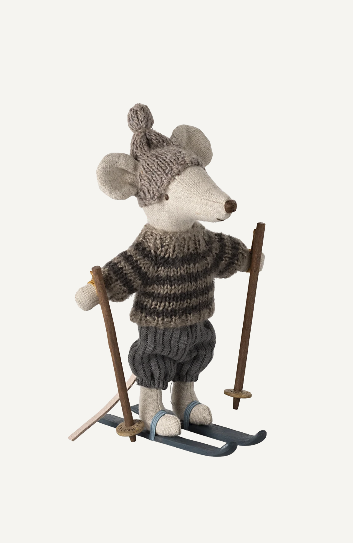 Maileg mouse toy in knit sweater, hat, and ski pants, holding wooden poles on blue skis.
