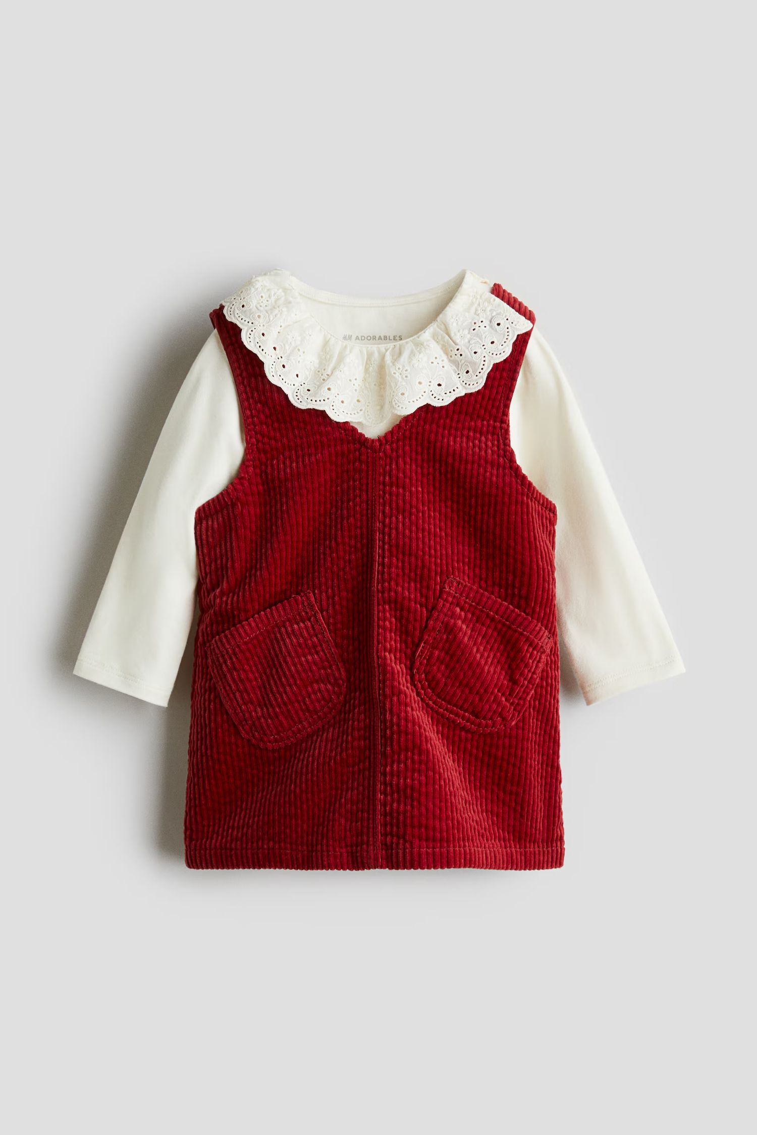 Red corduroy baby dress with ruffles and white lace collar shown laying flat in multiple angles.