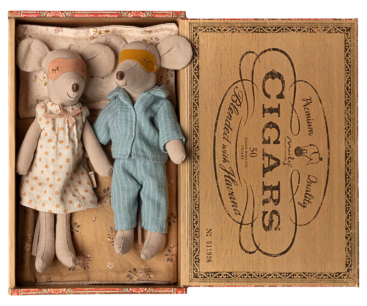 Two plush mouse toys in a vintage Cigars box, one wearing a polka dot dress and one in blue overalls.