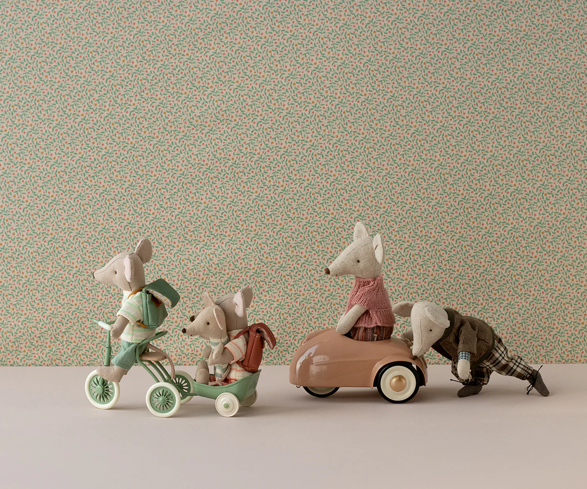 A collection of vintage toy cars and vehicles arranged in a row against a neutral beige background.