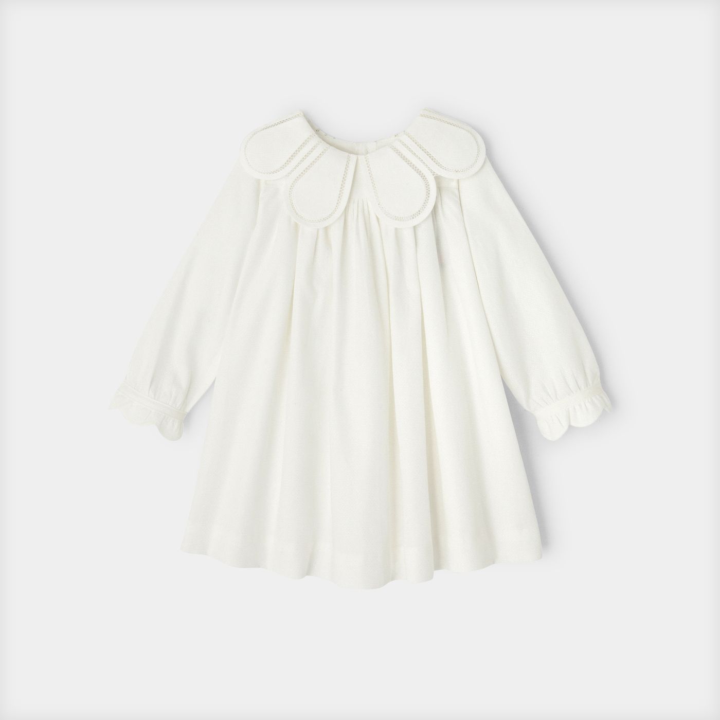 Delicate ivory pleated smock dress with peter pan collar and puff sleeves shown from multiple angles.
