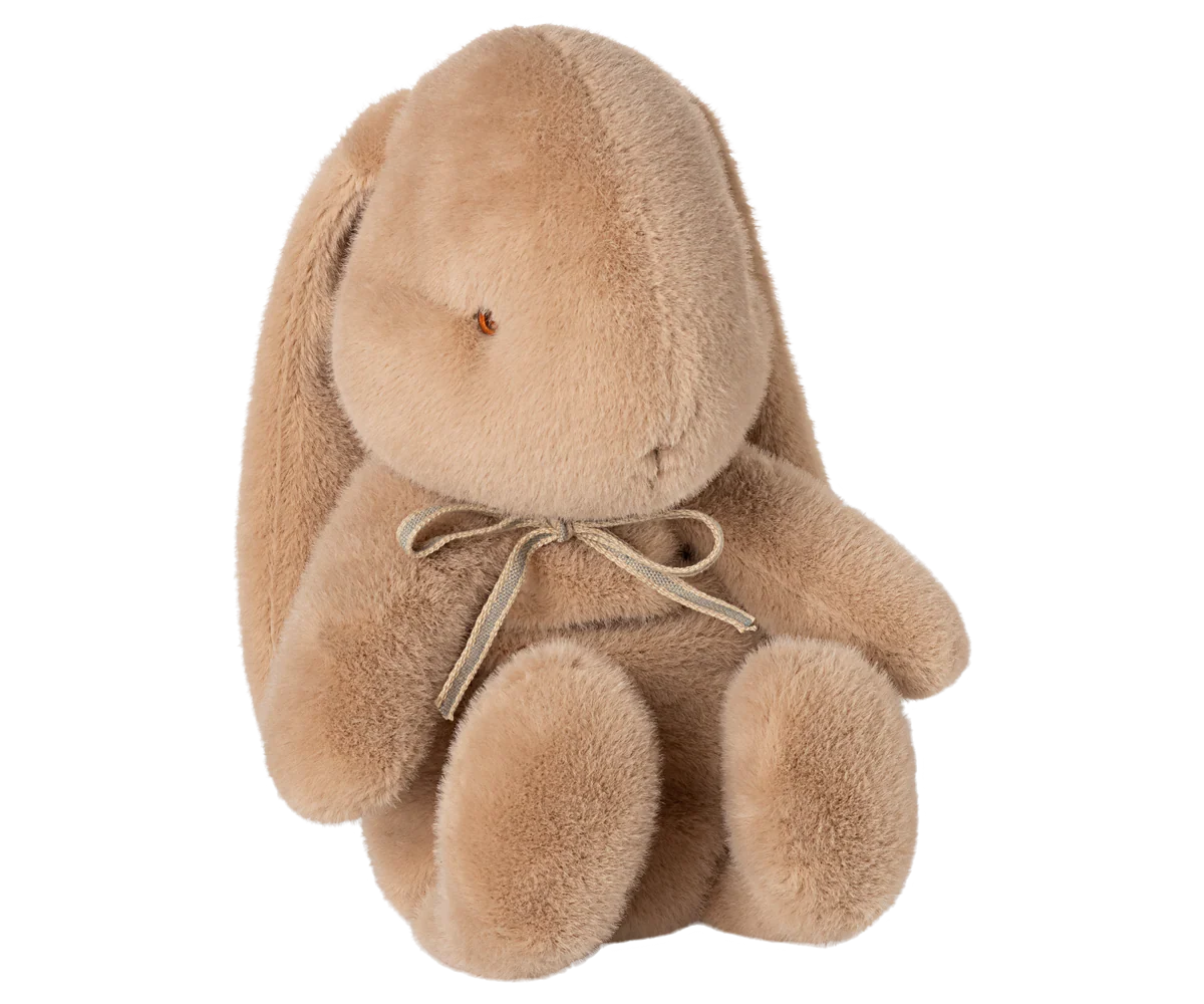Soft beige plush bunny stuffed animal with floppy ears and a decorative bow around its neck.
