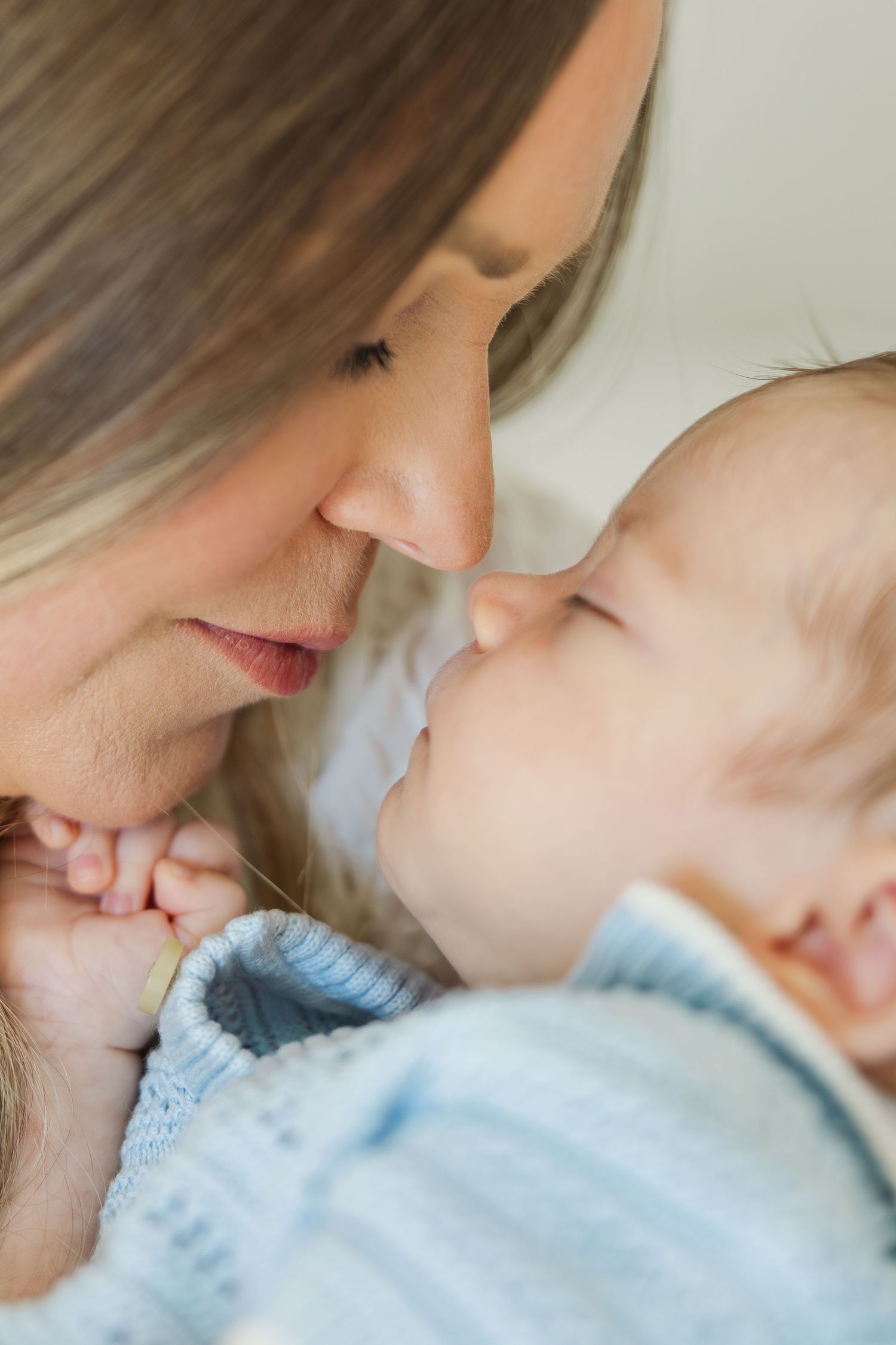 A tender moment between a mother and her baby touching noses during a houston newborn photography session.