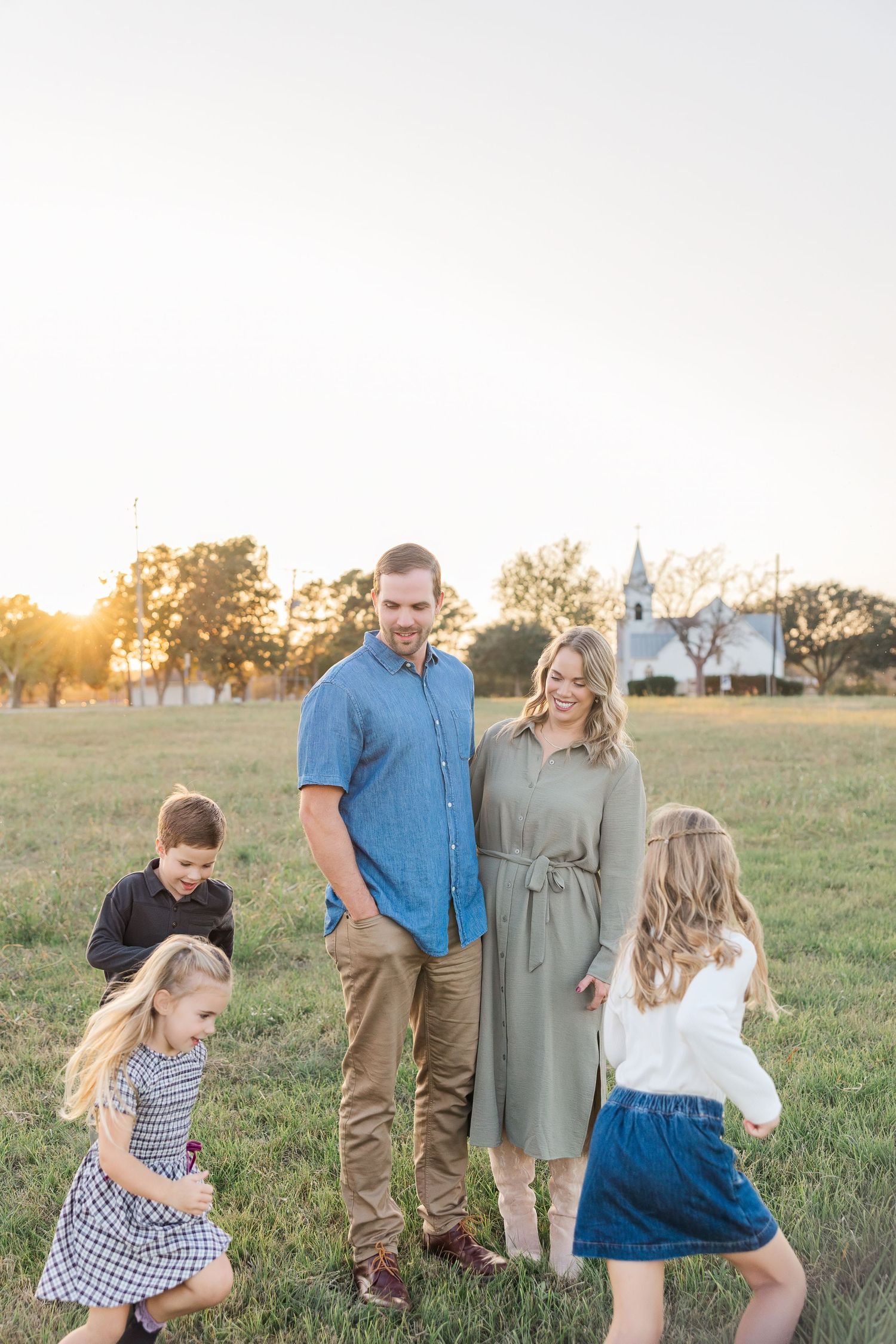 Family of five enjoying a golden hour sunset during a session with a Houston family photographer.