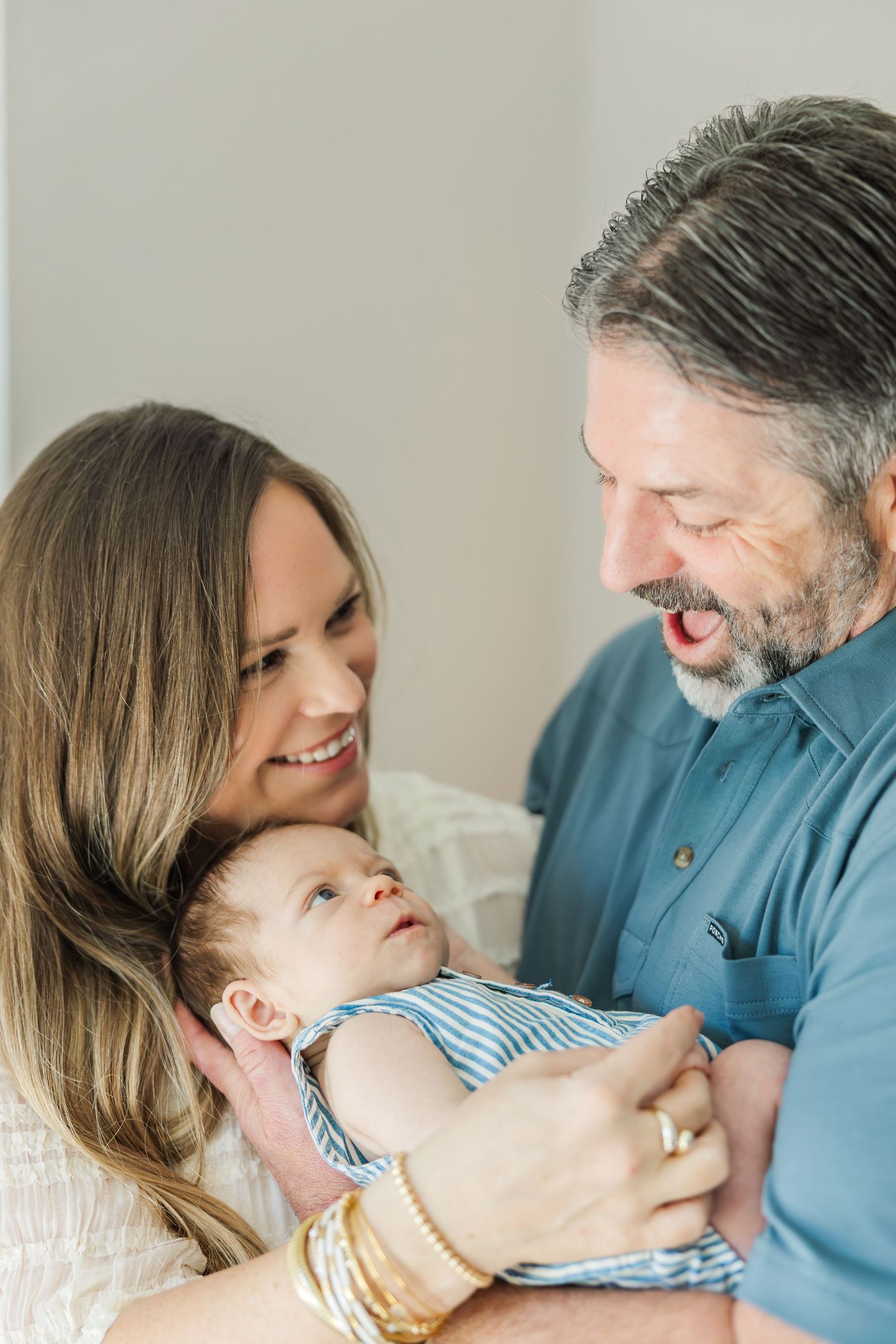 Happy couple smiling at their newborn baby during a Houston newborn photography session.
