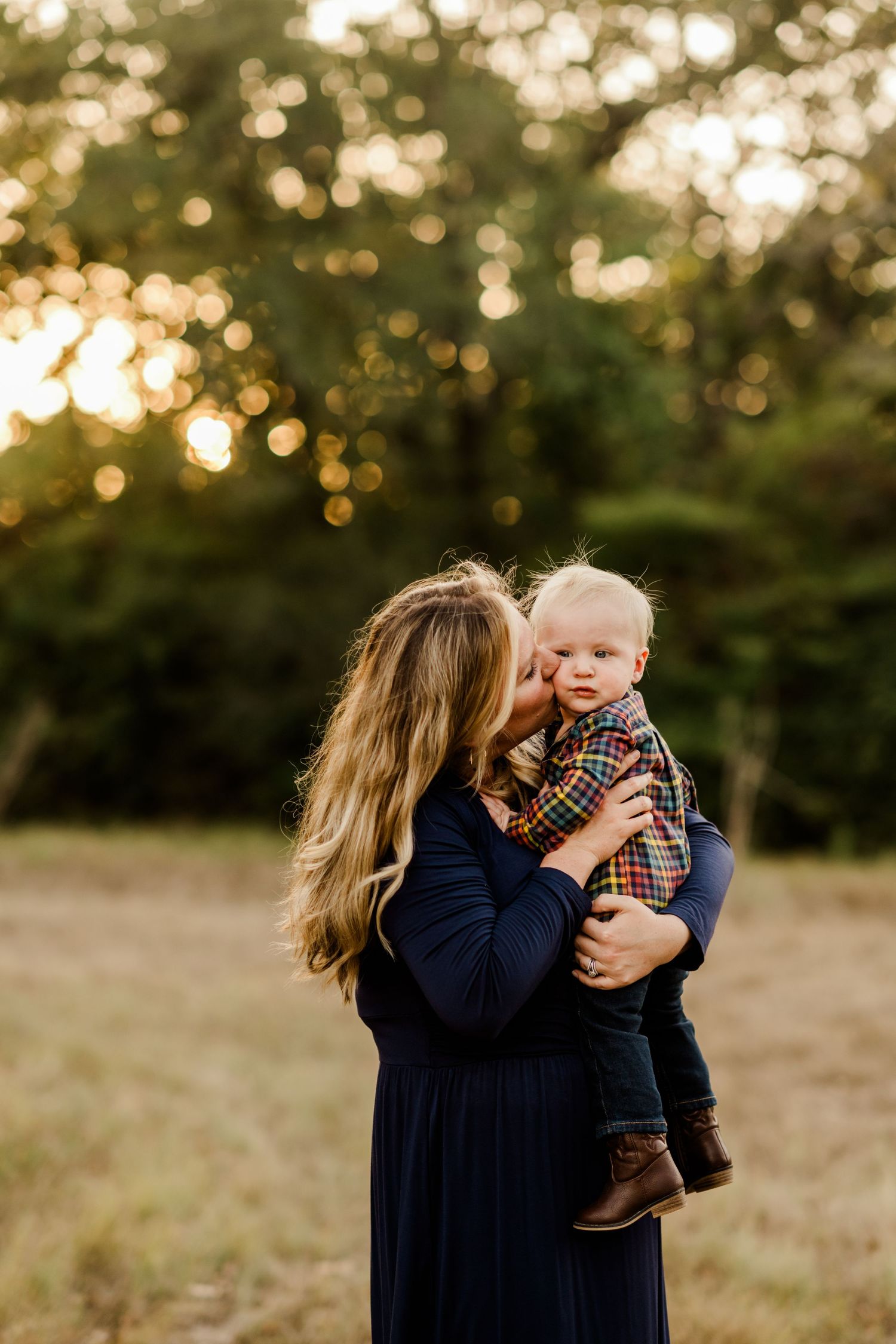 A tender moment between parent and child captured in golden sunset light outdoors.