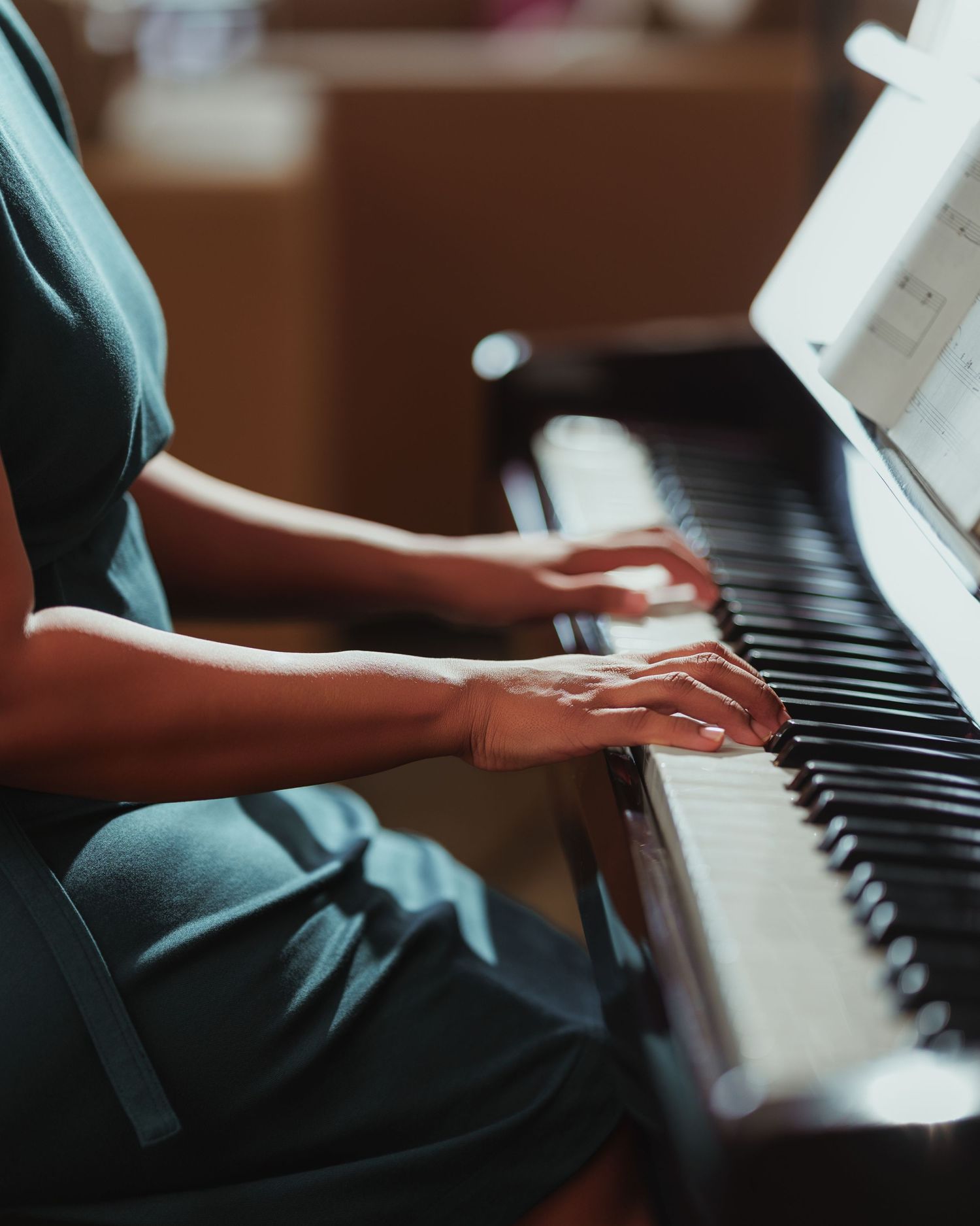 Close-up shots of hands playing piano keys in dramatic lighting.