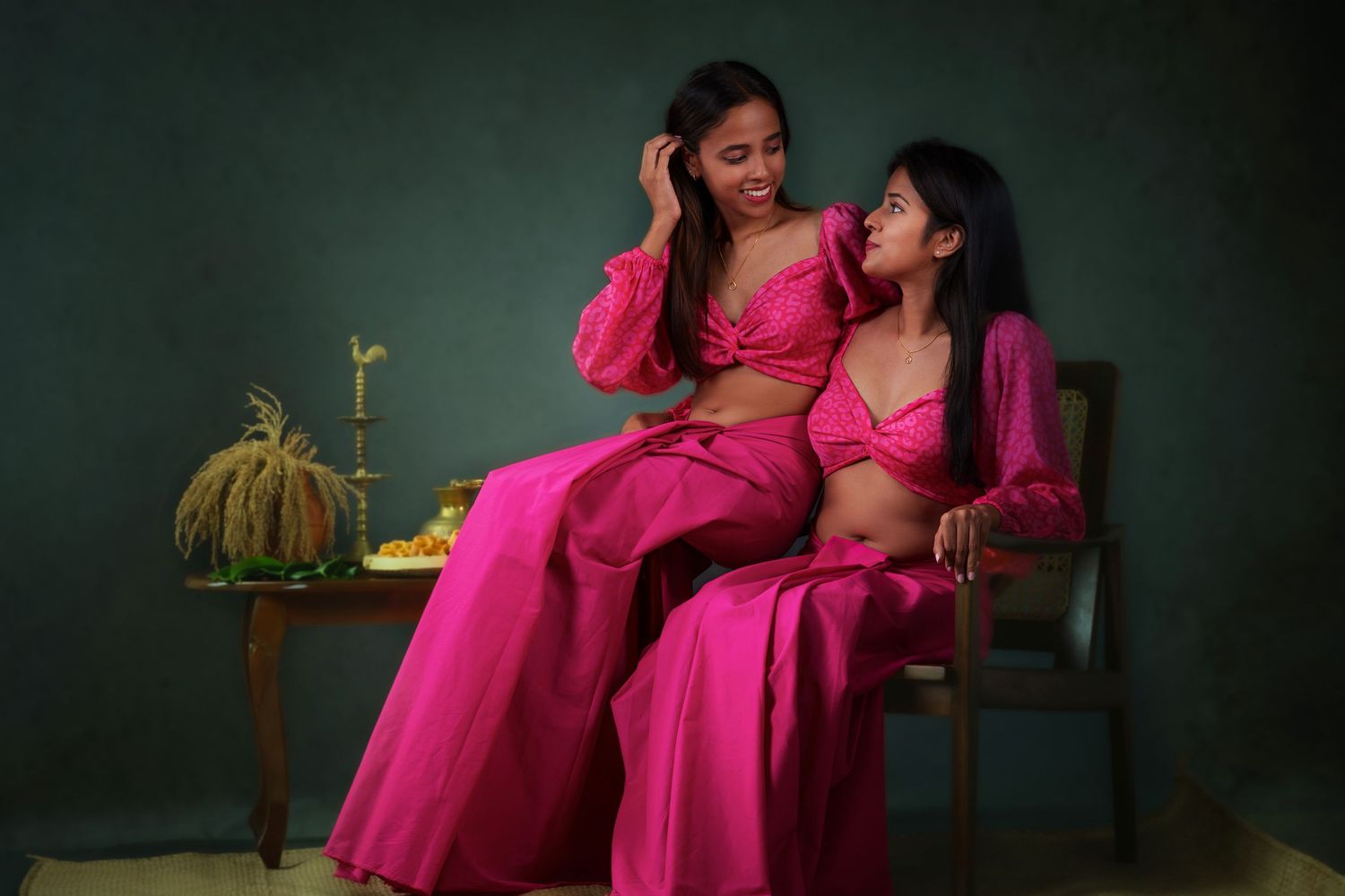 An intimate maternity photoshoot with a flowing pink dress in moody lighting.
