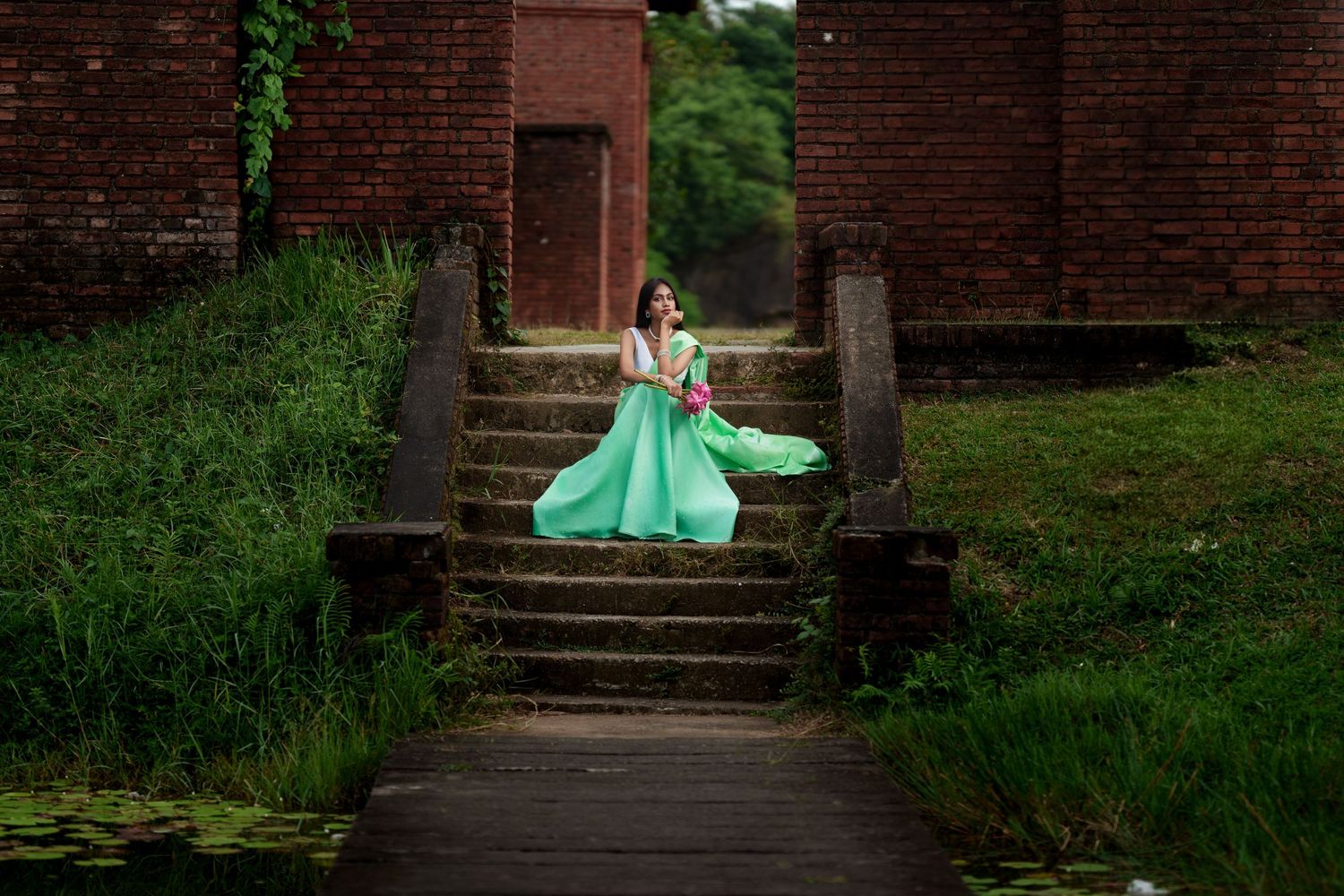 A serene portrait session at an old brick building with green ivy and stone steps.