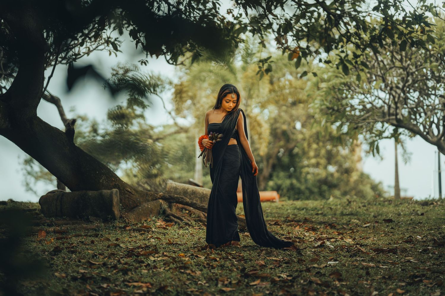 A dreamy outdoor photoshoot under trees with natural lighting and shadows.