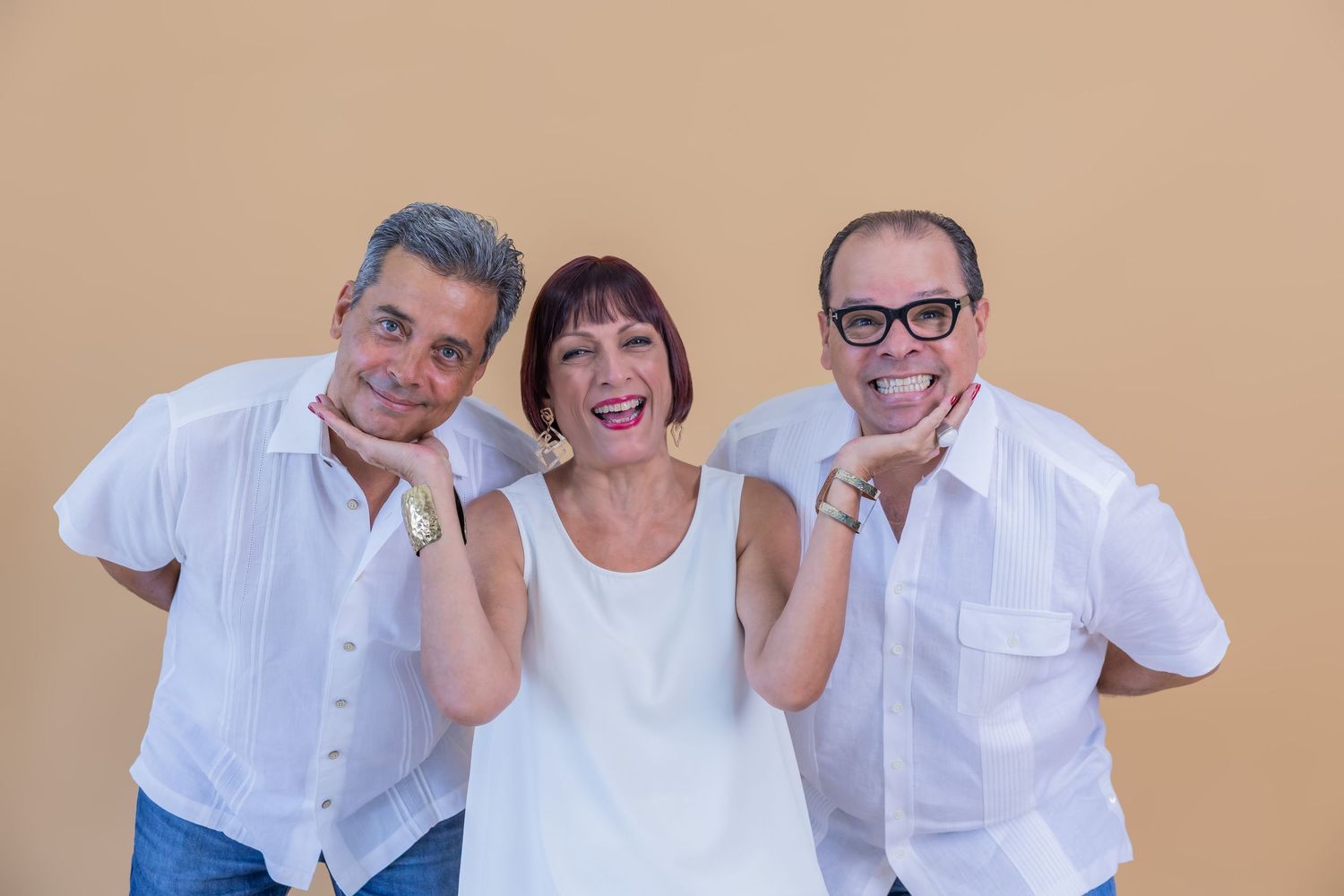 Three people in white shirts pose playfully together for a casual photo shoot.
