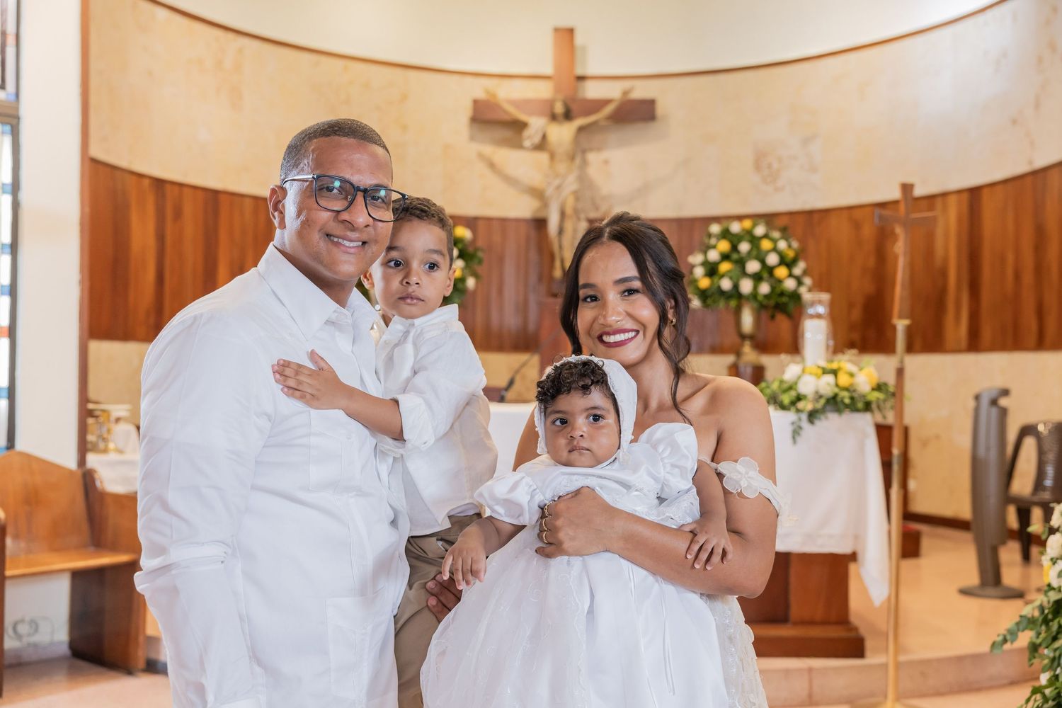 Wedding party members in white attire share joyful moments during a celebration in a wood-paneled venue.