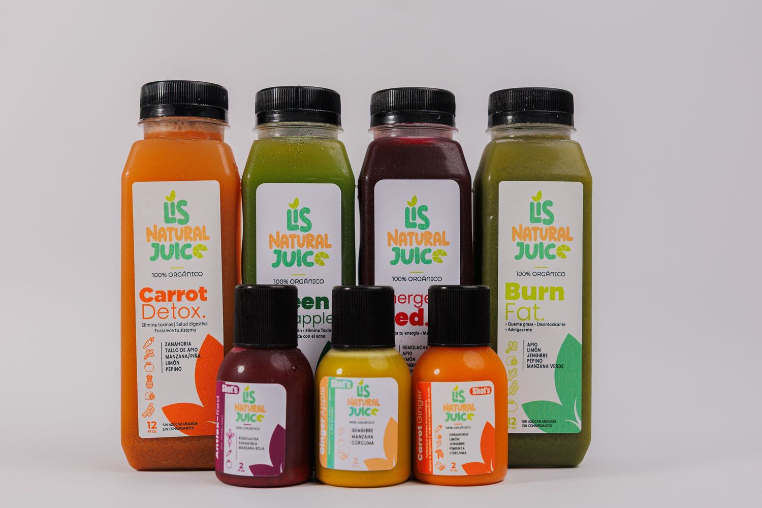 Assorted IIS Natural Juice bottles including Carrot Detox, Green, and Burn flavors displayed on white background.