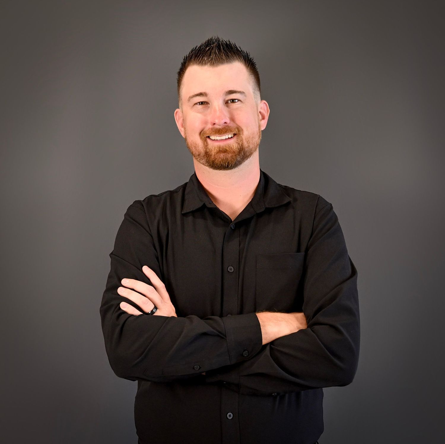 Professional headshot portrait series of someone in a black button-up shirt against dark background showing different poses.
