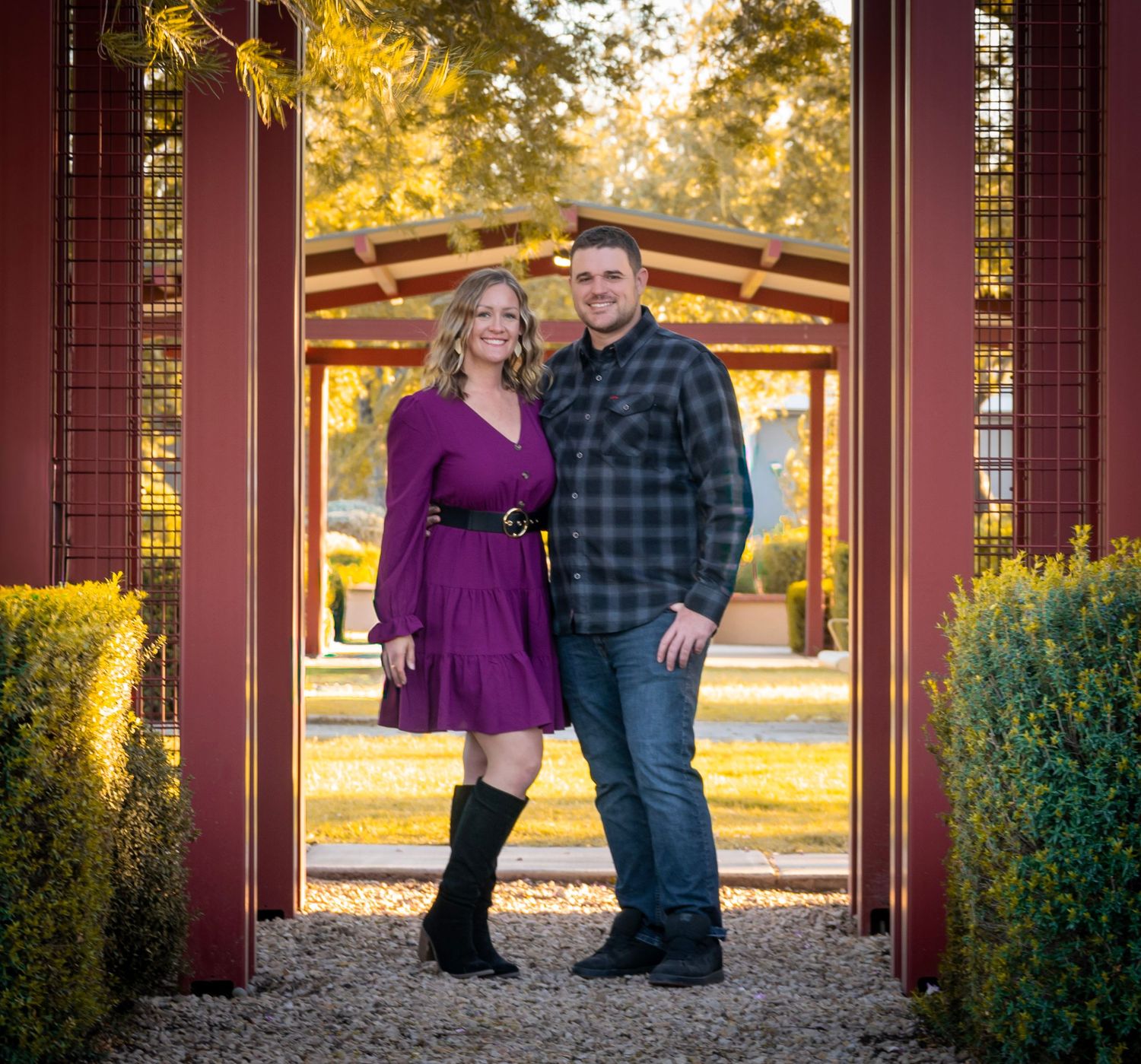 A panoramic view of a couple in a covered walkway surrounded by fall foliage.