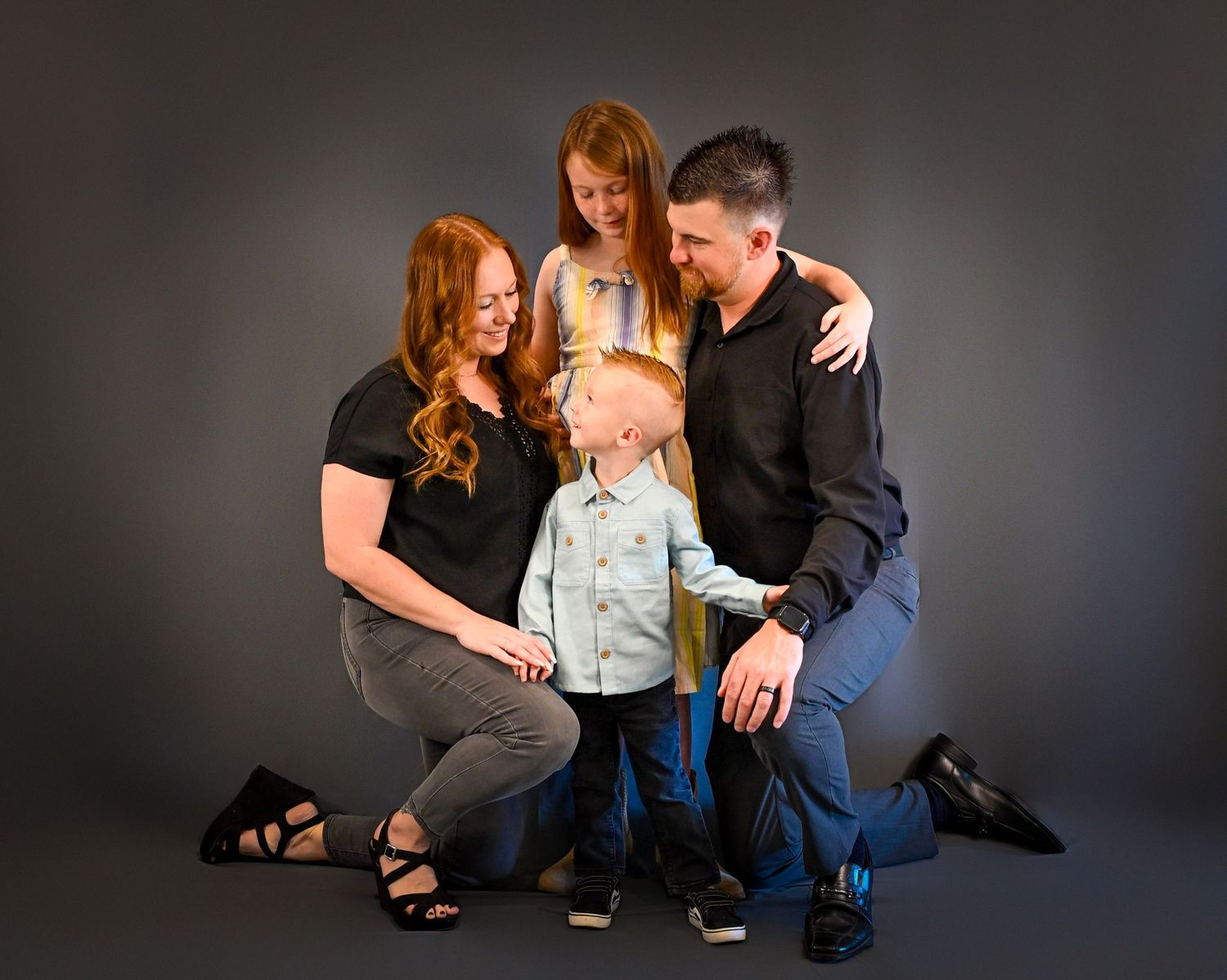A series of intimate studio portraits showing a couple in casual attire against a dark backdrop.