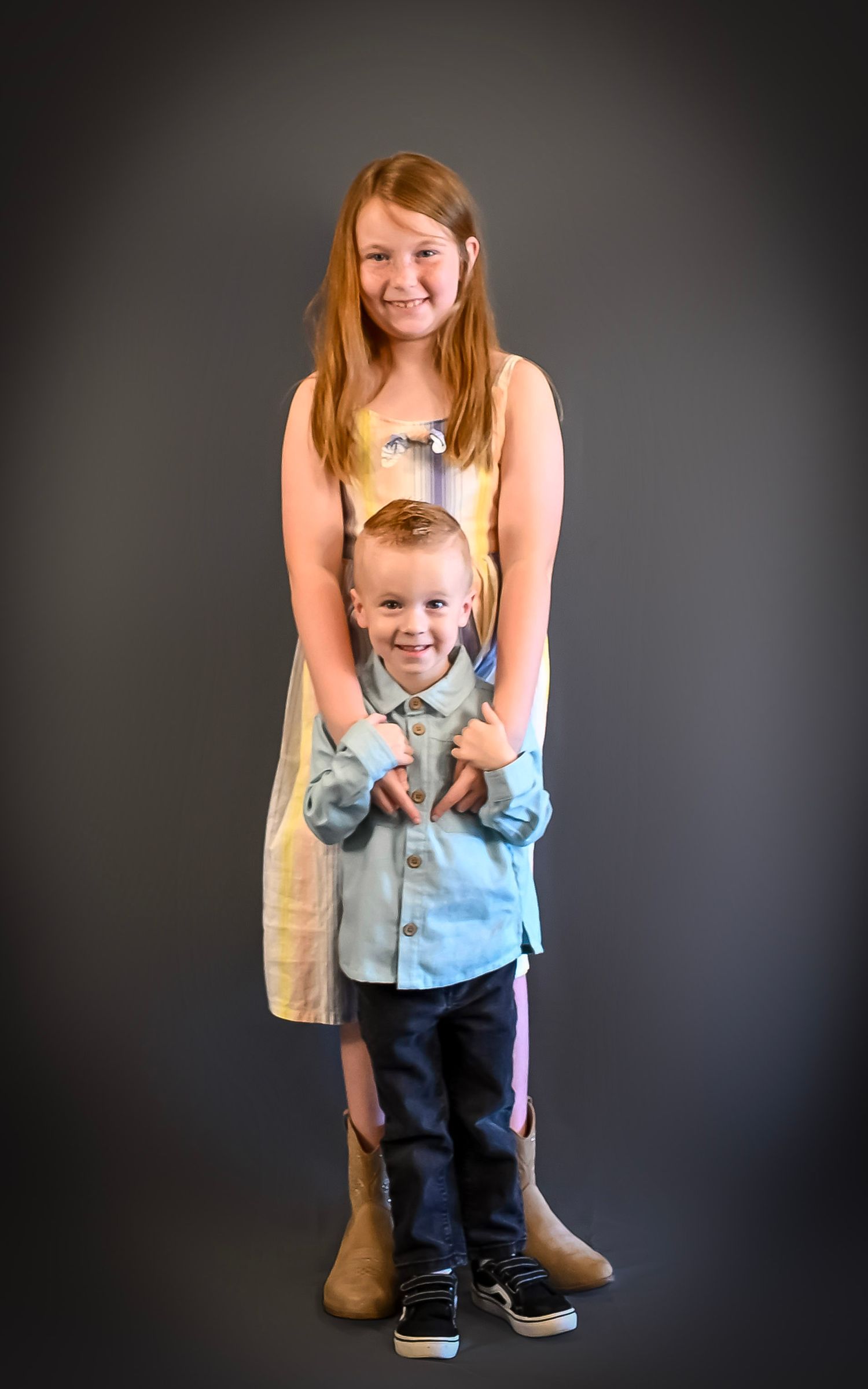 Studio portrait against dark background showing playful poses and interactions between two people.