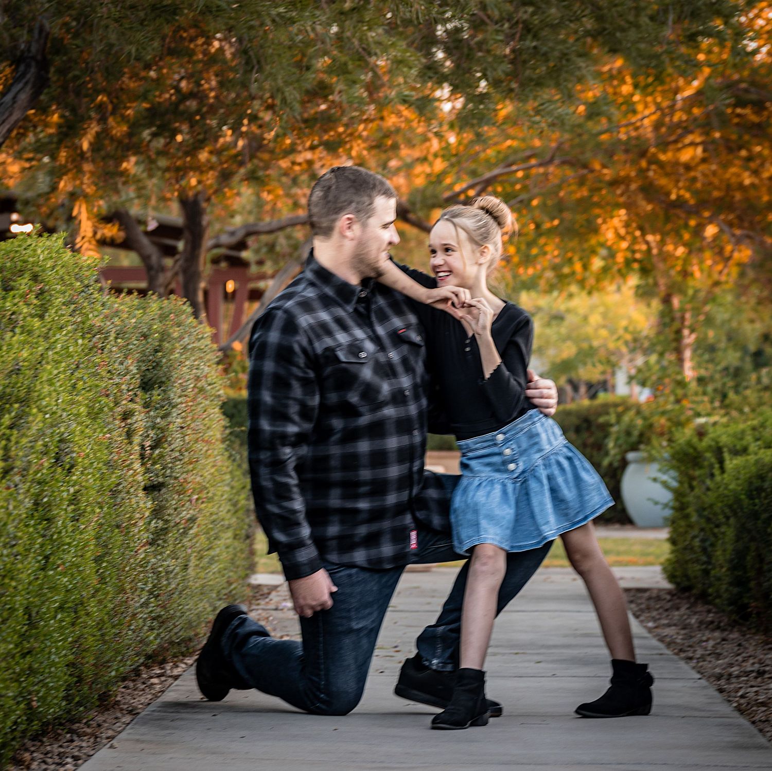 Candid moments captured between a couple on a garden path during sunset.