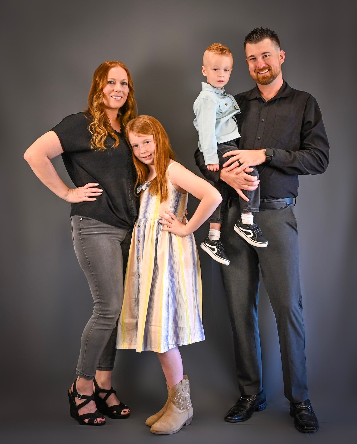 A family of three poses together in a studio setting with grey background showing progression of different poses.