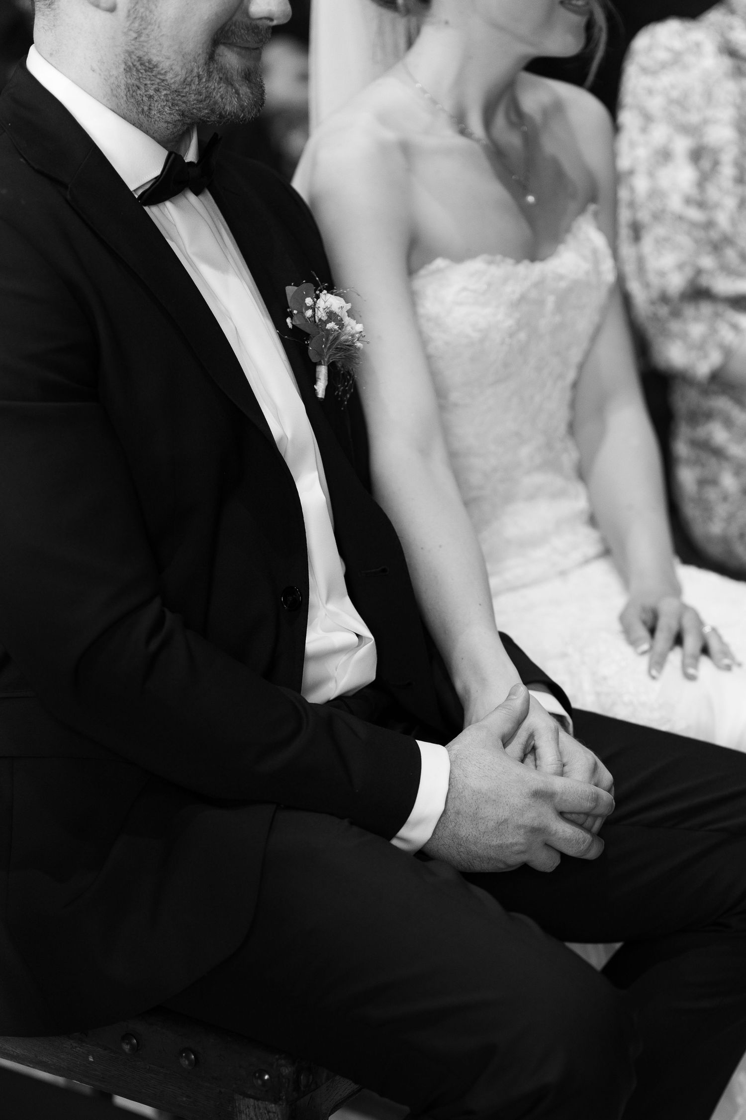 Close-up black and white shot of formal wedding attire details.