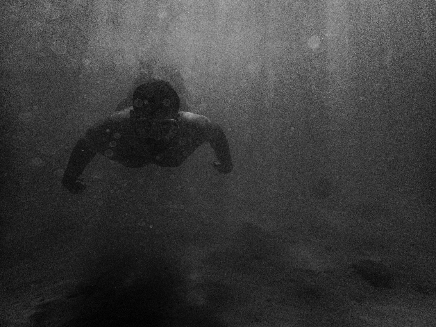 Underwater scene with rays of light filtering through dark water.
