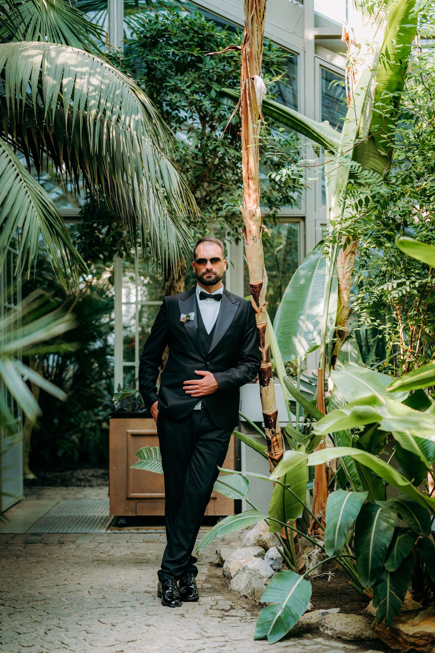 A series of formal portraits in a lush tropical garden setting with palm trees and greenery.