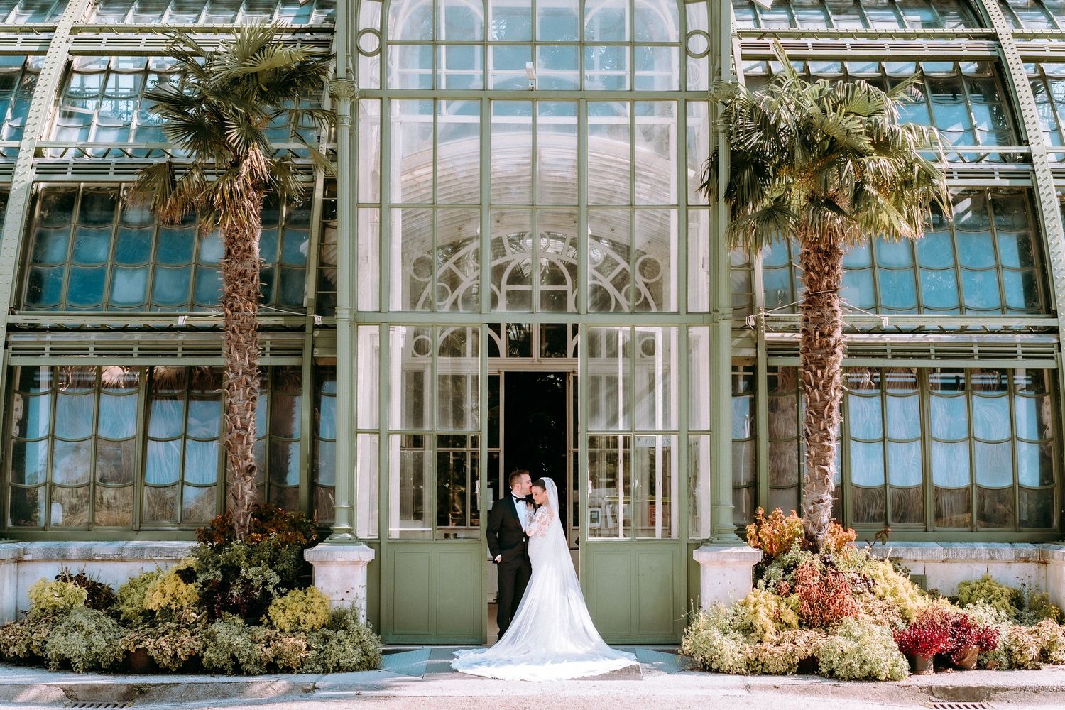 Elegant conservatory wedding venue with grand glass architecture and tropical plants.