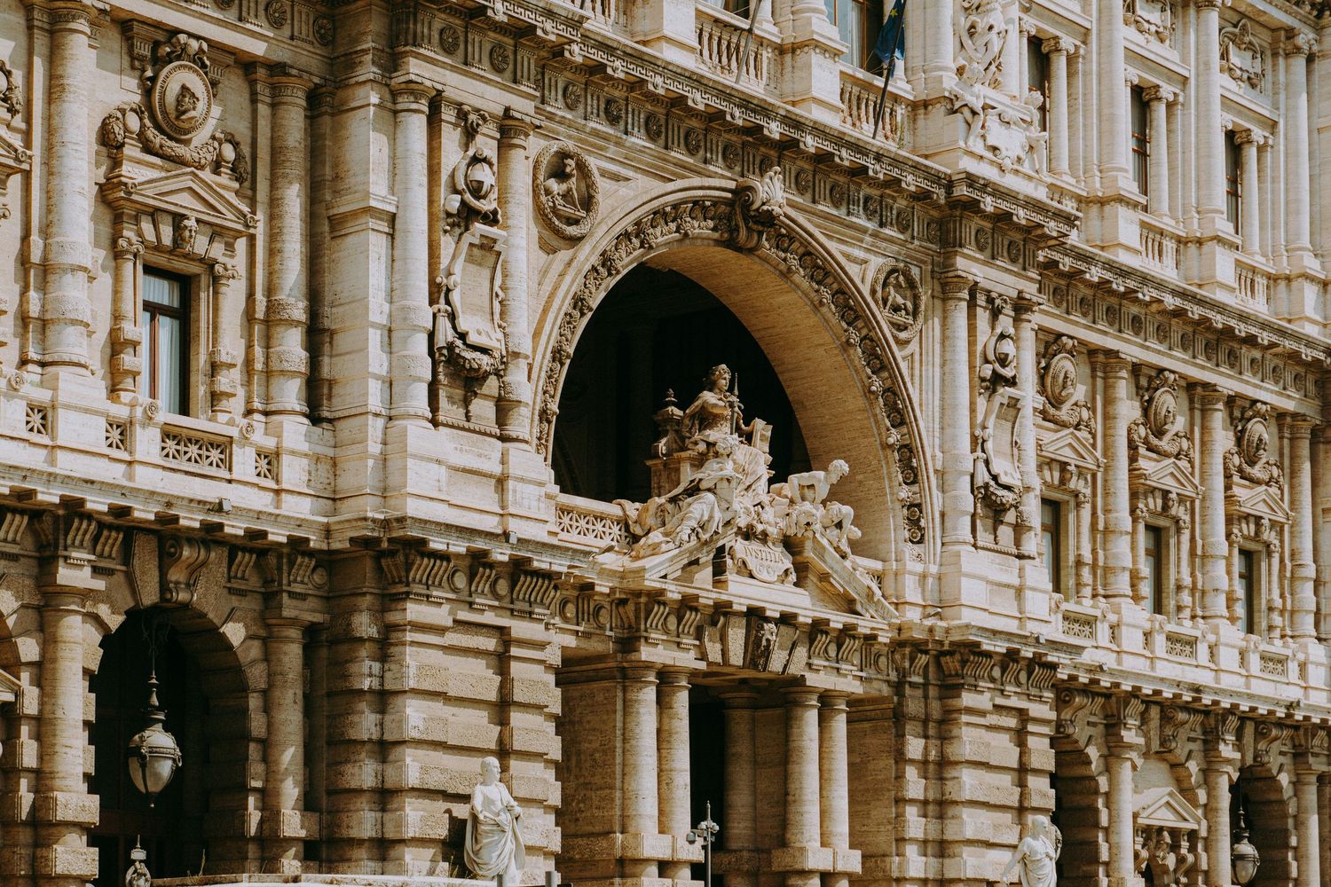 Ornate classical architecture with detailed stone carvings and arches along a historic building facade.
