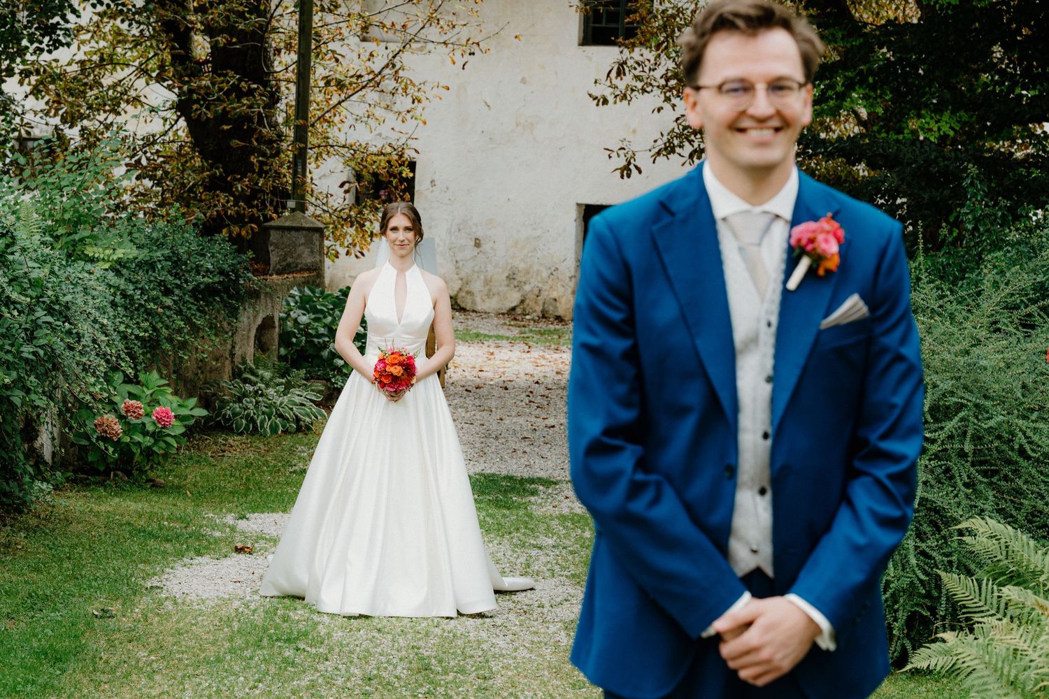 Wedding photo sequence in front of a historic white building with blue suit details.