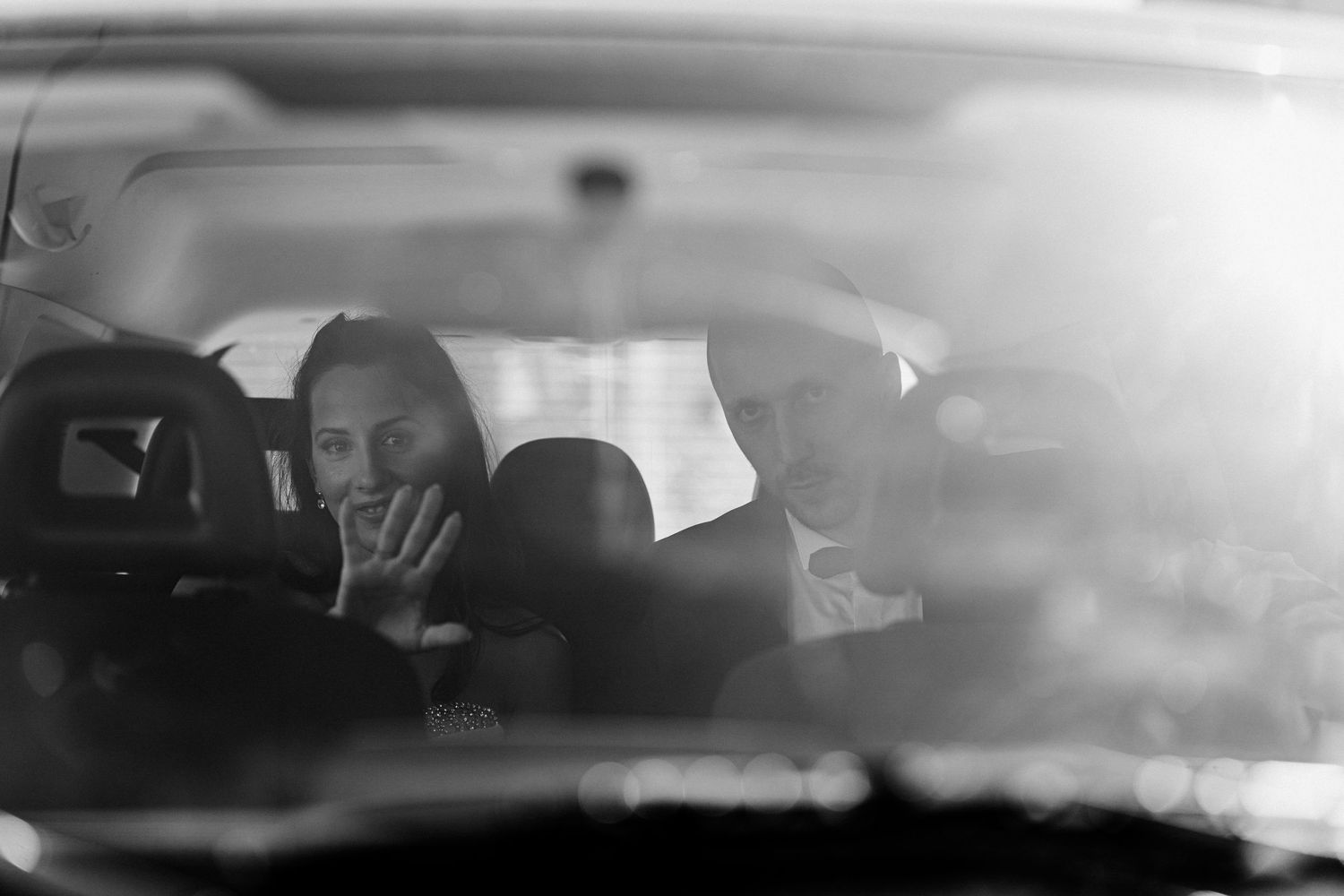 Artistic black and white wedding photo through car window.