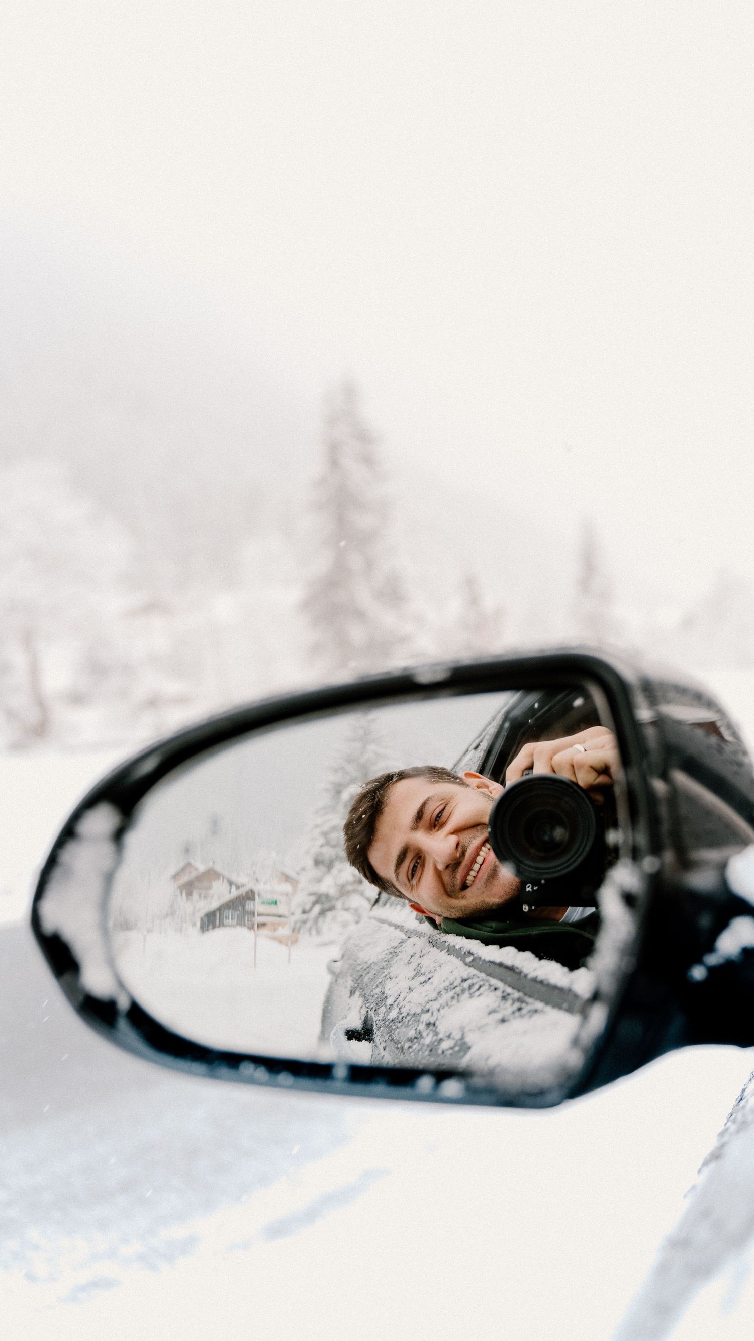 Creative winter portrait series reflected in a snow-covered car side mirror.