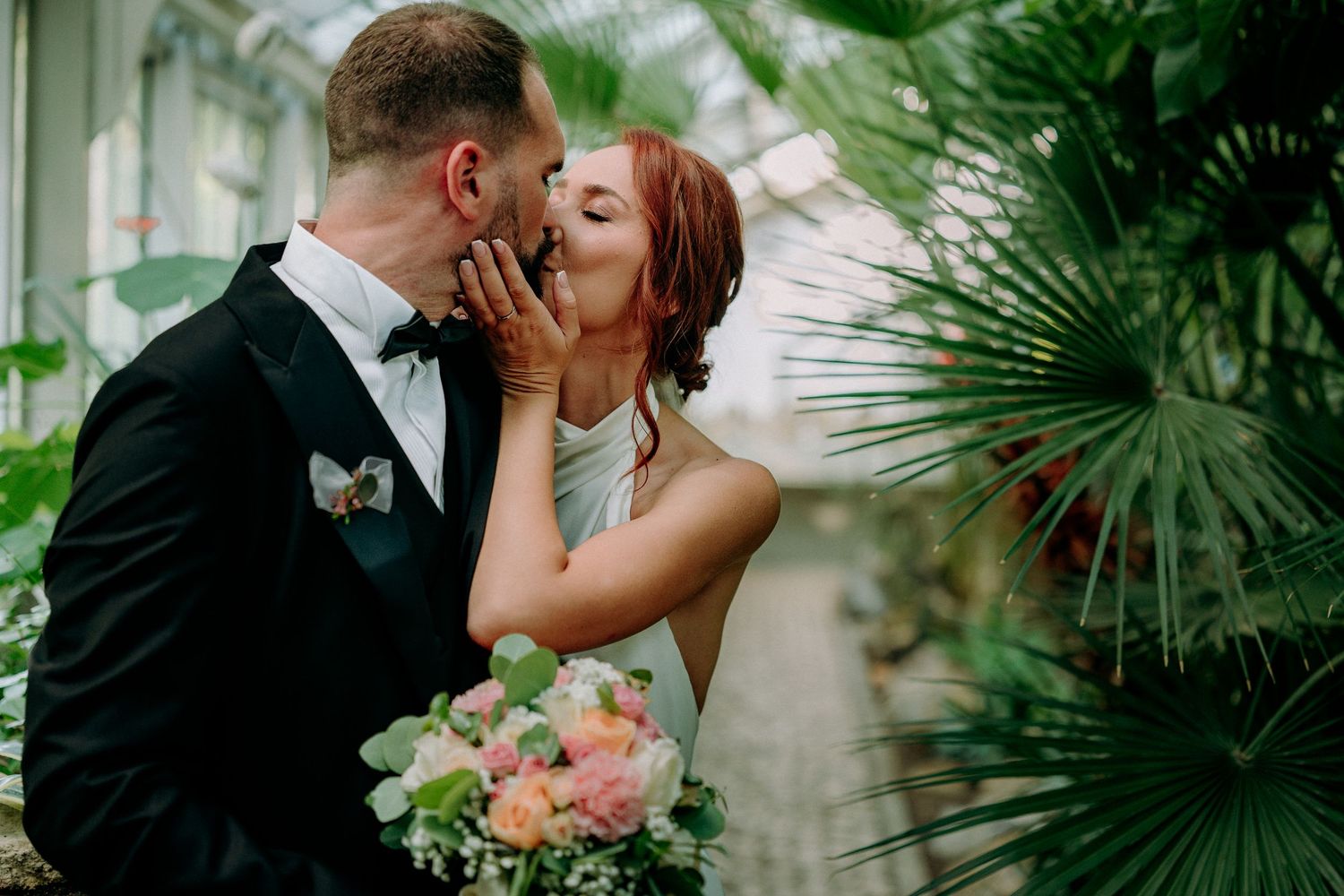 Romantic greenhouse wedding photos with tropical plants and natural lighting.