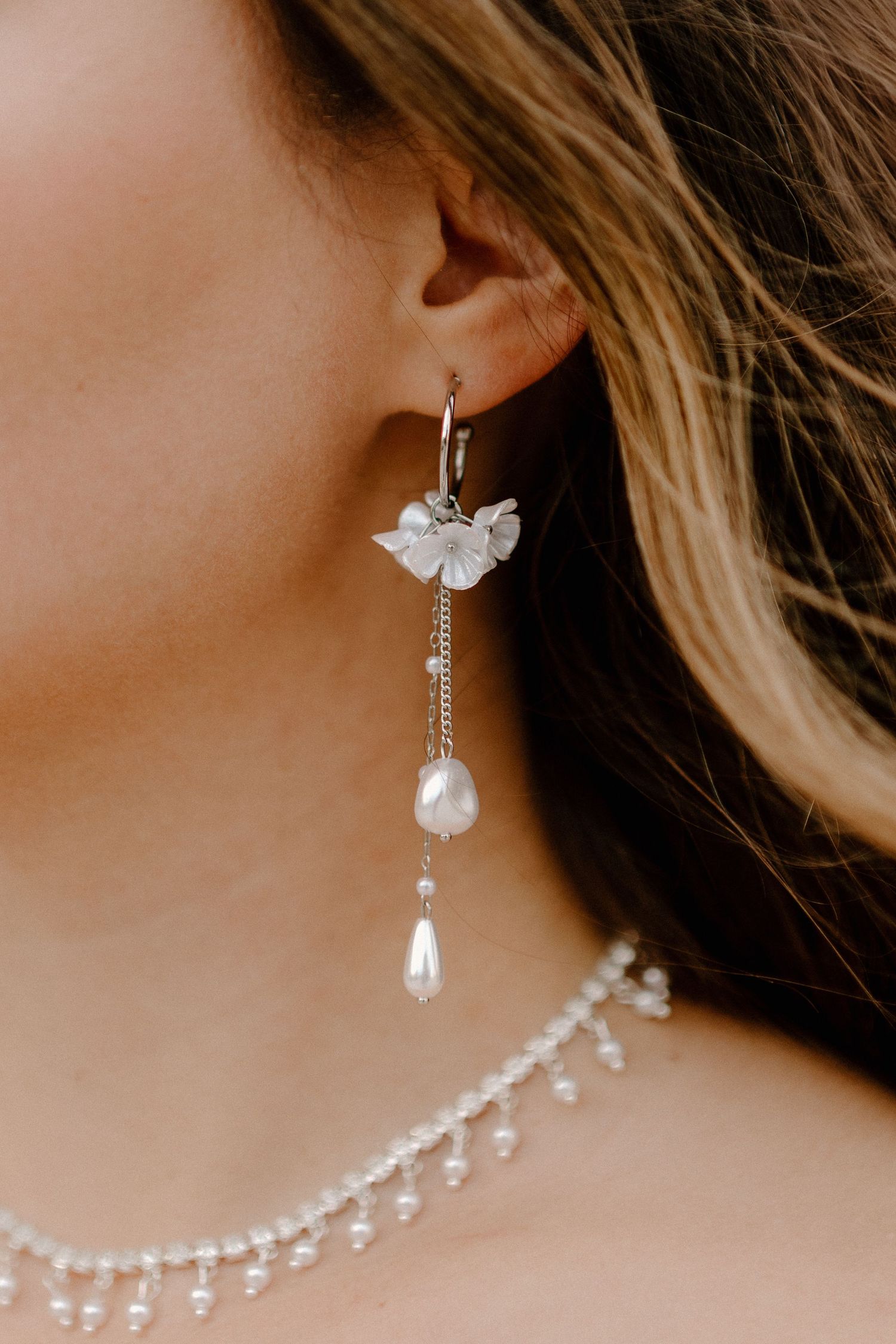 Elegant pearl drop bridal earrings with delicate crystal chains shown in a progression of angles against a neutral background.