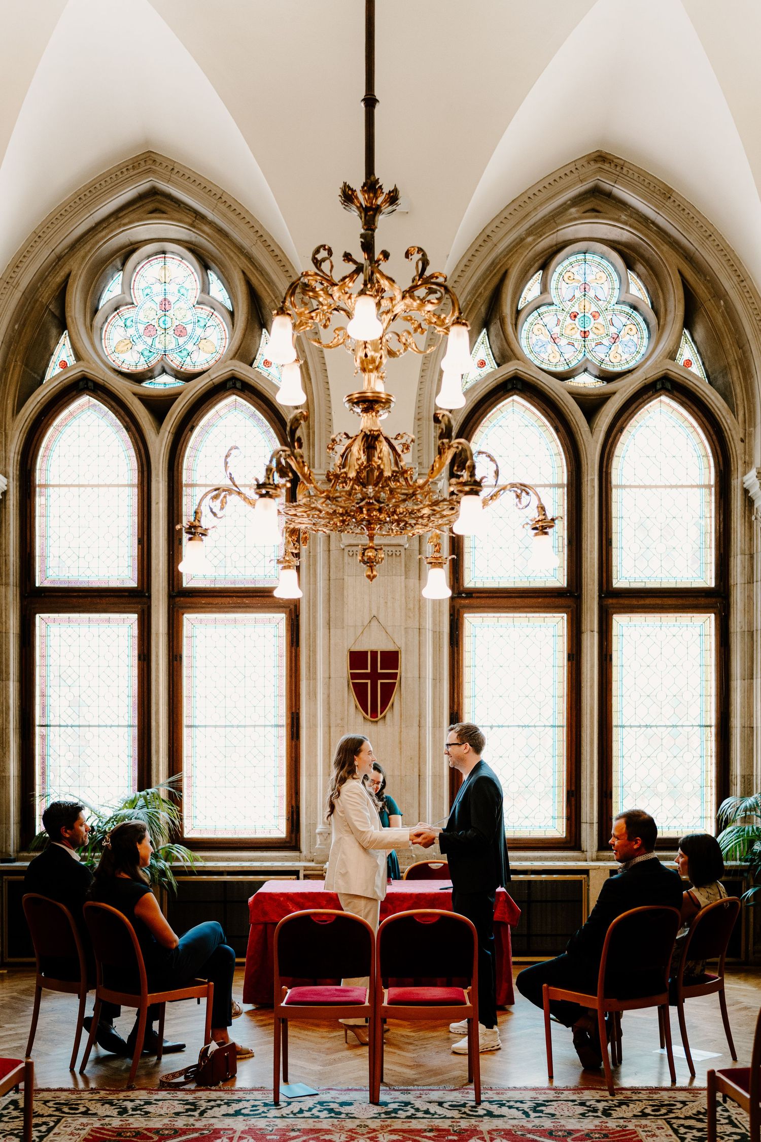 Gothic revival room with arched stained glass windows and elegant chandeliers.