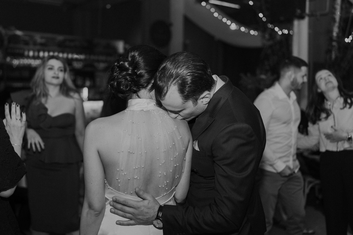 Candid moments of wedding guests dancing and celebrating on the dance floor.