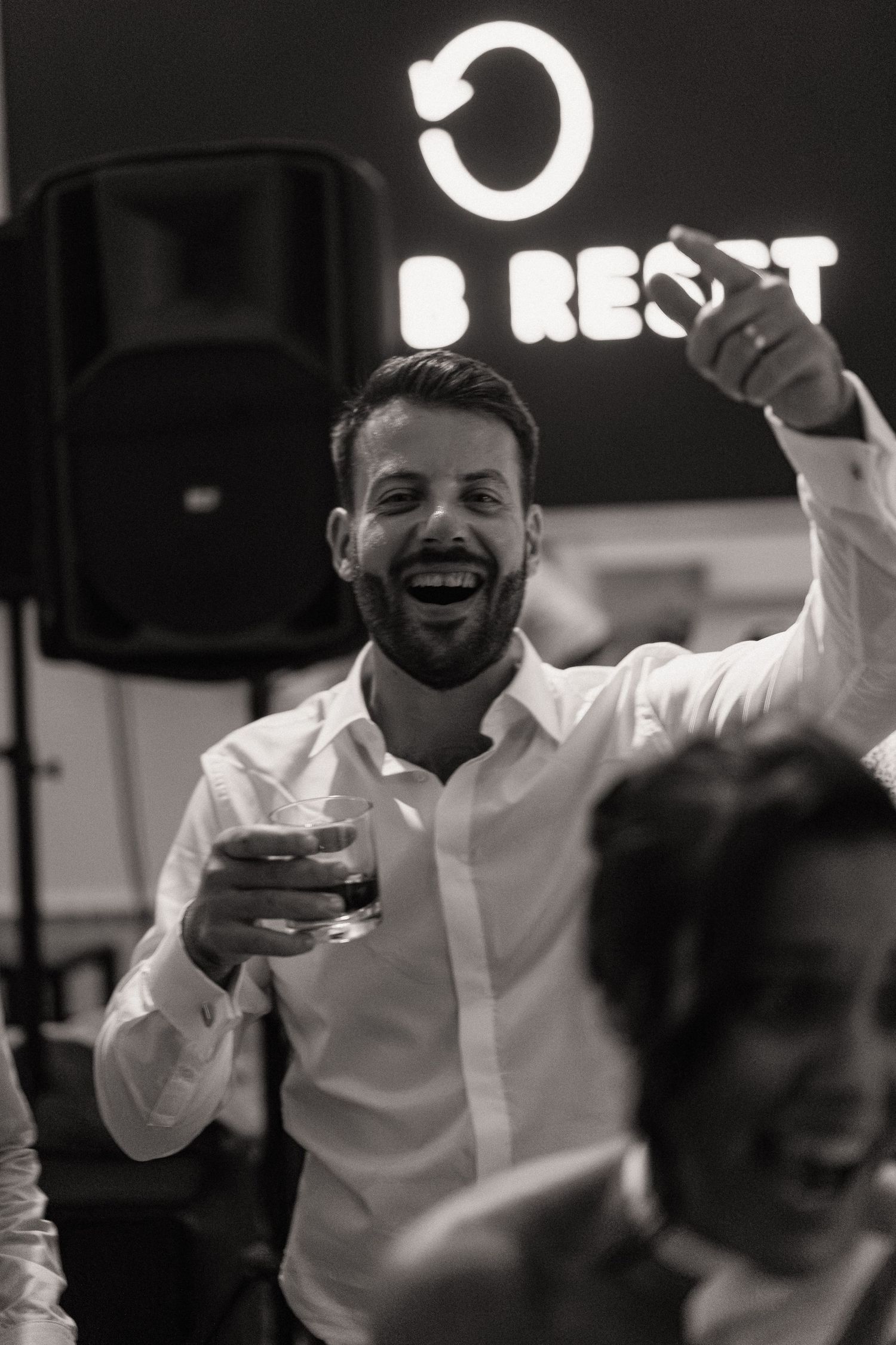 Black and white photo of guests dancing and celebrating at a lively party.