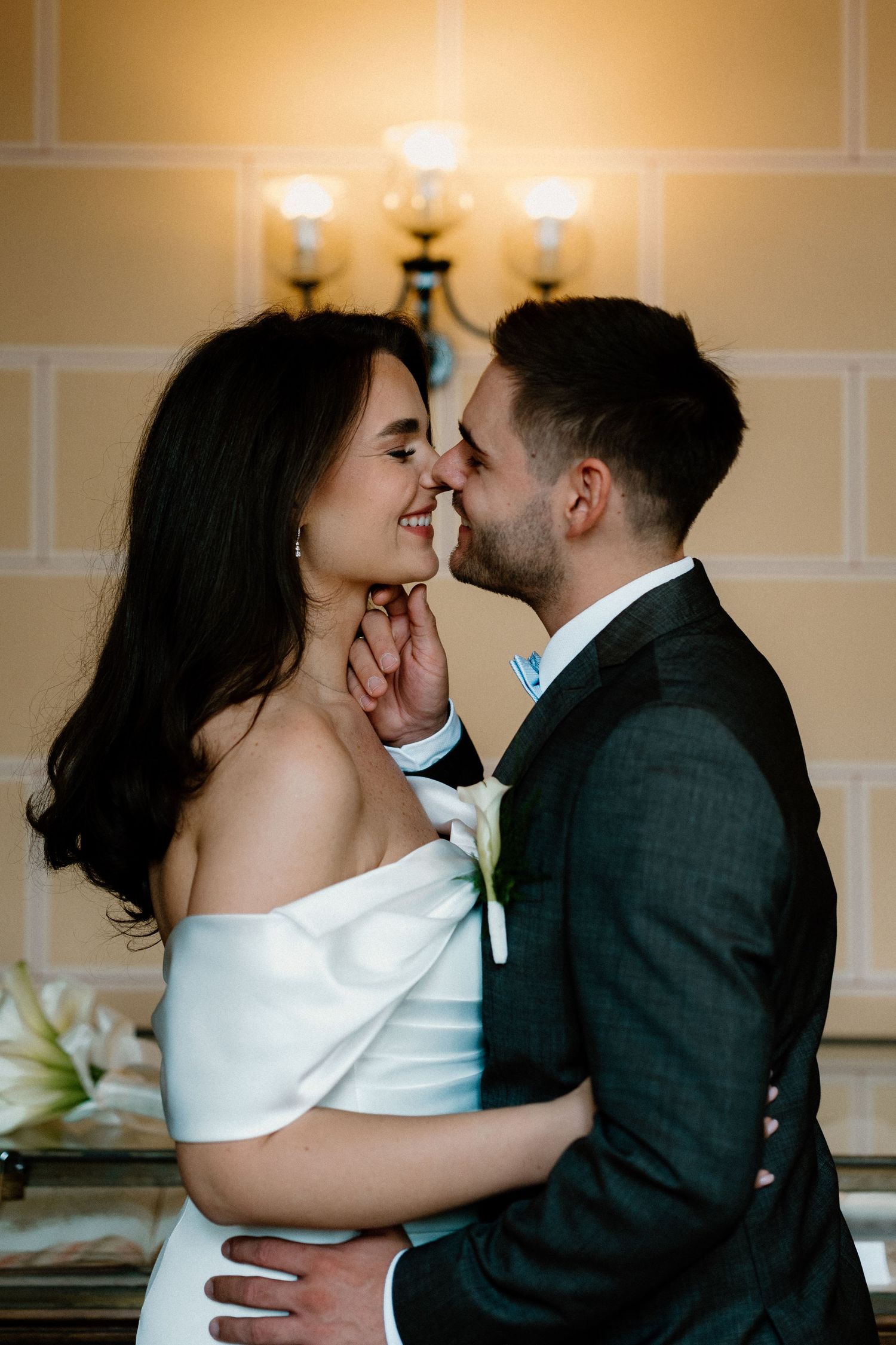 Intimate wedding couple shares tender moments in a warmly lit indoor setting.