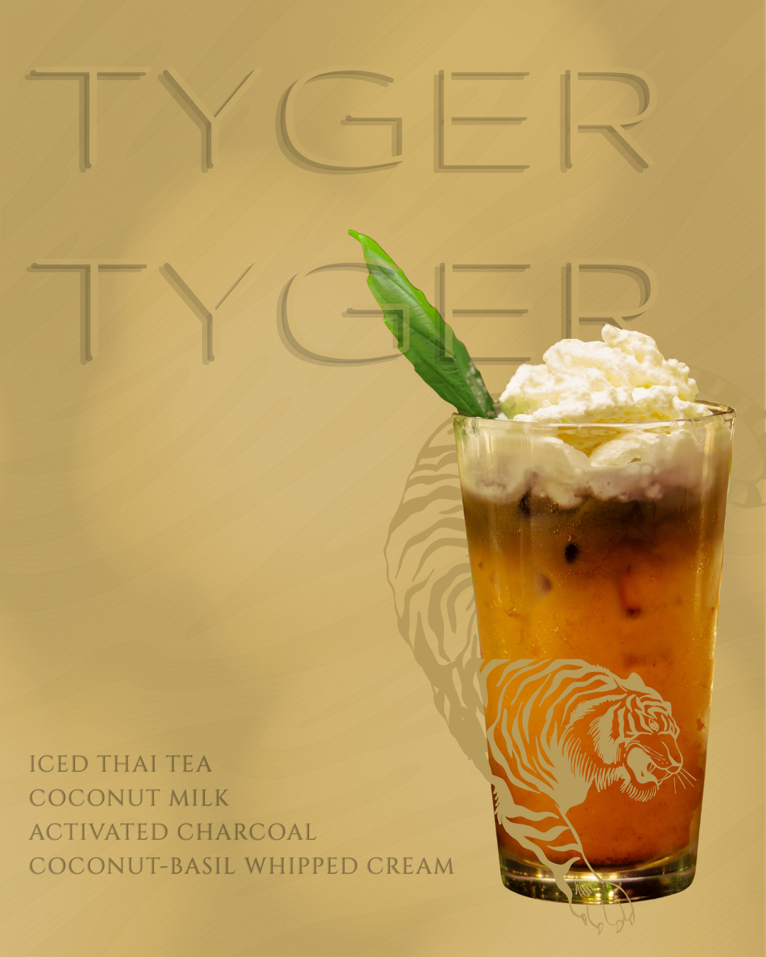 Tyger Tyger iced Thai tea drink with coconut milk, activated charcoal, and coconut-basil whipped cream in tiger-etched glass.
