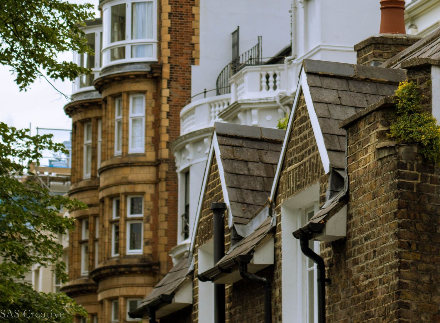 Victorian red brick and white stucco residential buildings with bay windows in London.