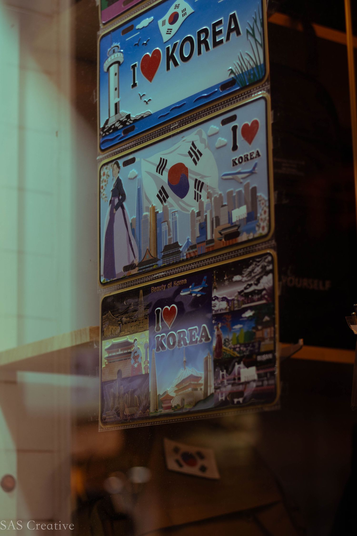 Collection of I Love Korea souvenir magnets displayed in a shop window in South Korea.