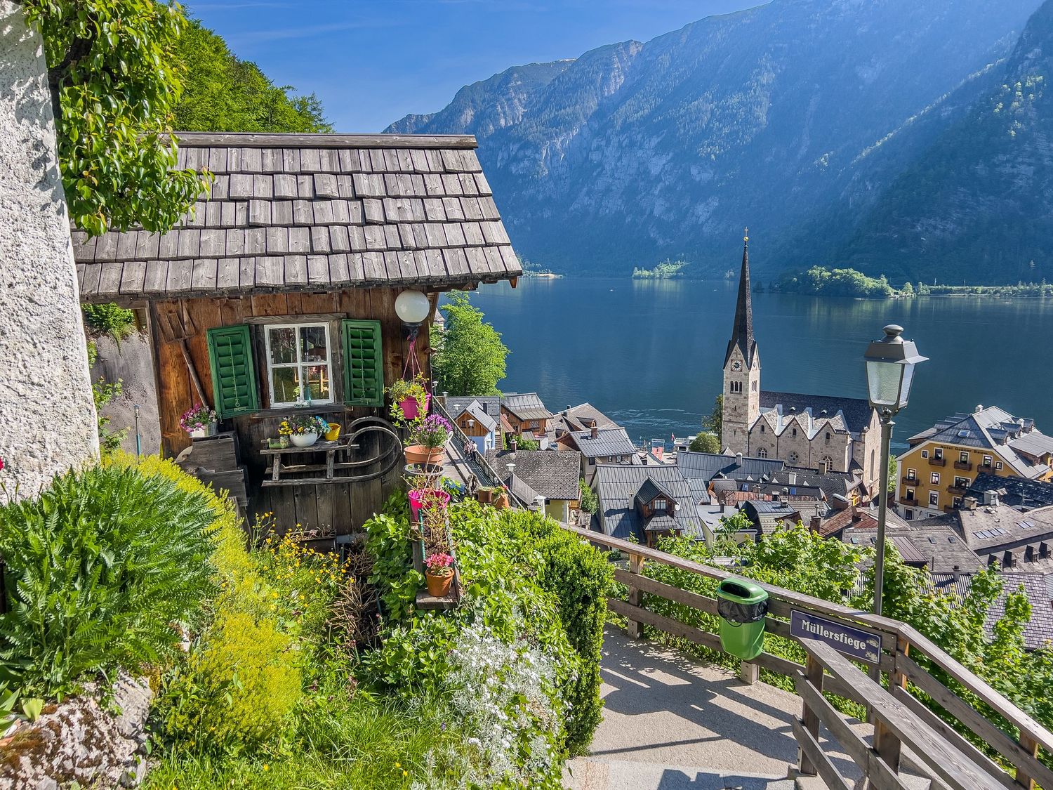 Scenic panoramic view of Hallstatt village in Austria with traditional houses nestled between mountains and lake.