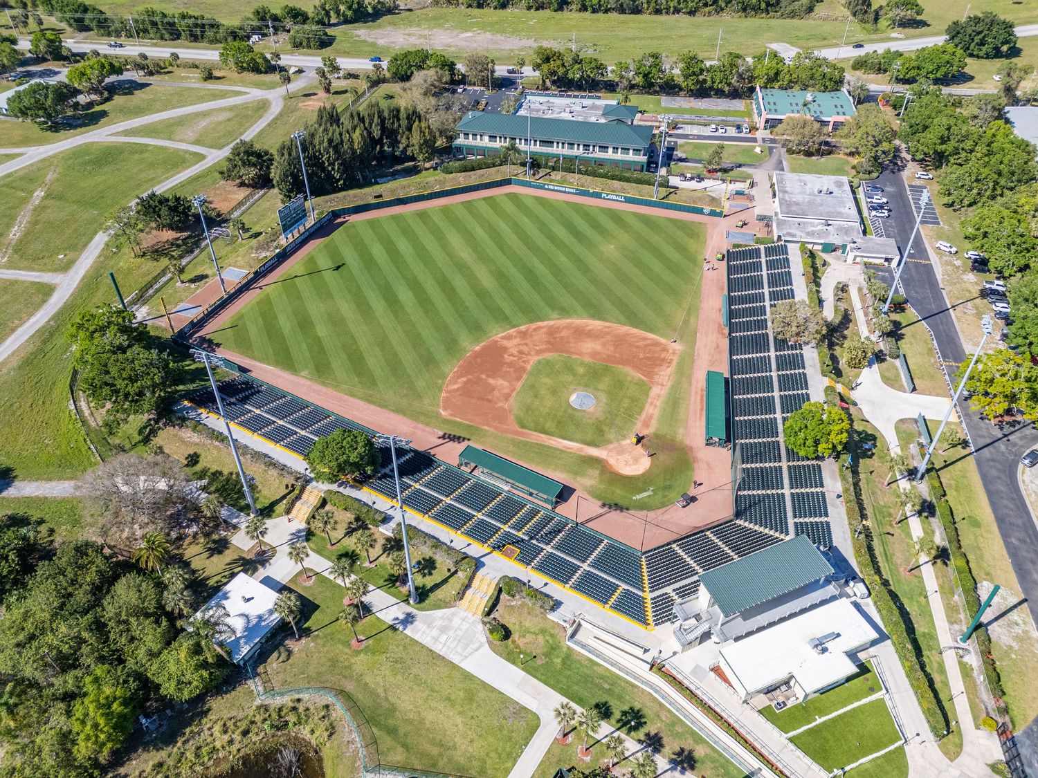Aerial view of multiple baseball fields and sports facilities surrounded by green landscaping and parking areas.