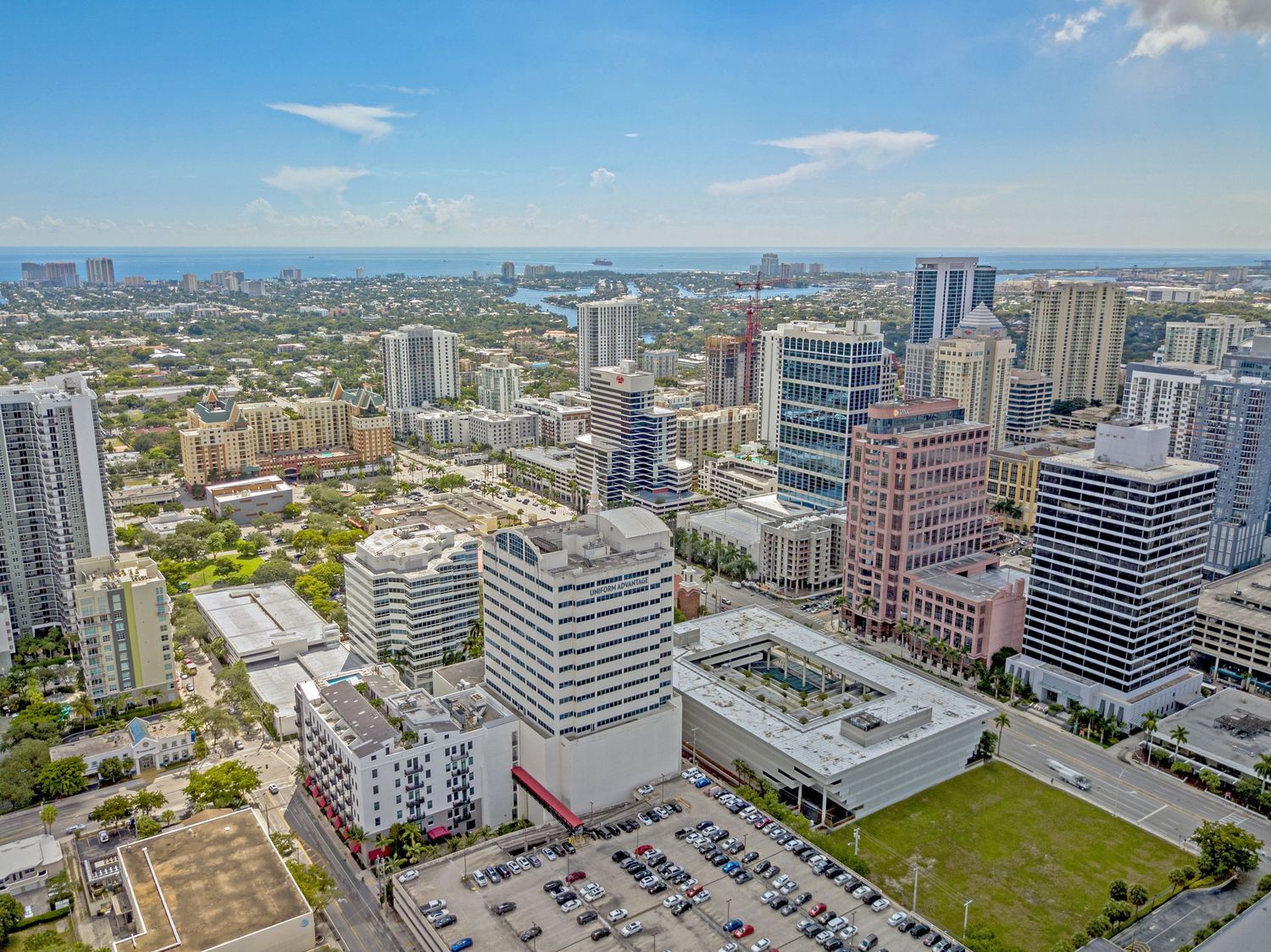Aerial panoramic view of downtown Miami's modern skyline with high-rise buildings and office towers against blue sky.