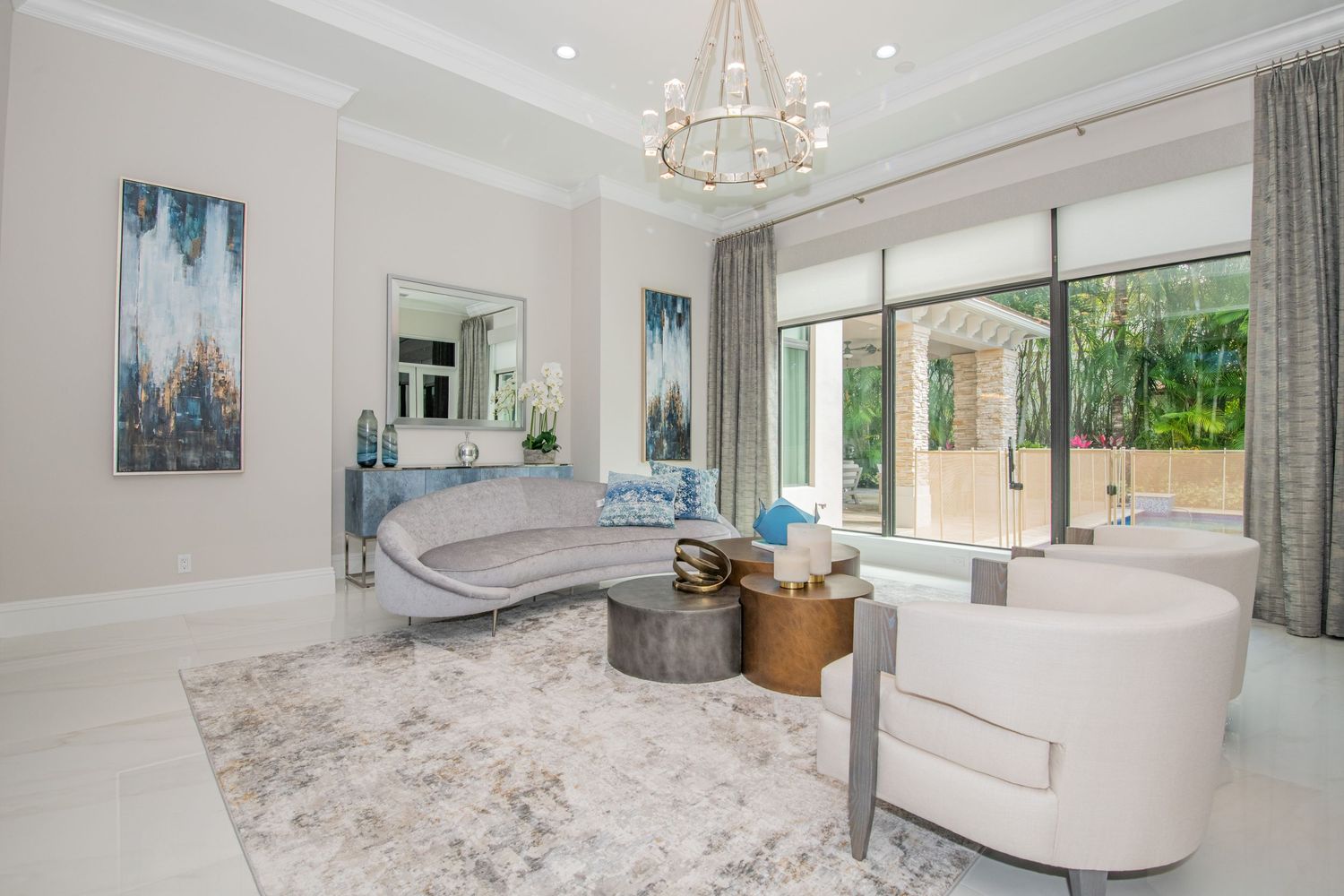 A modern white and gray luxury bathroom interior with chandelier, marble countertops, and elegant fixtures.